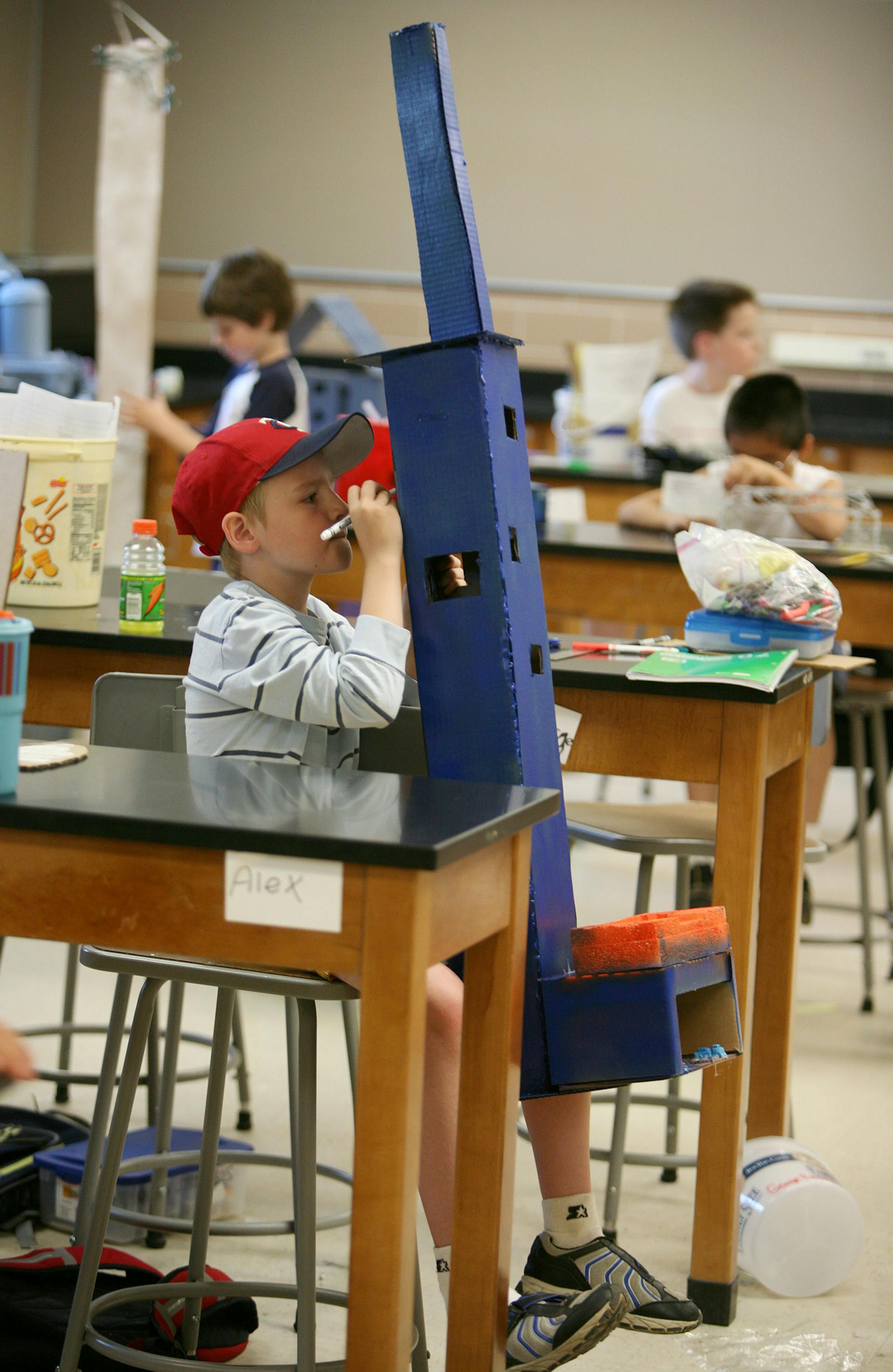 Alex Olds, 9, put the finishing touch on his cardboard building that he named Sears Tower II.
