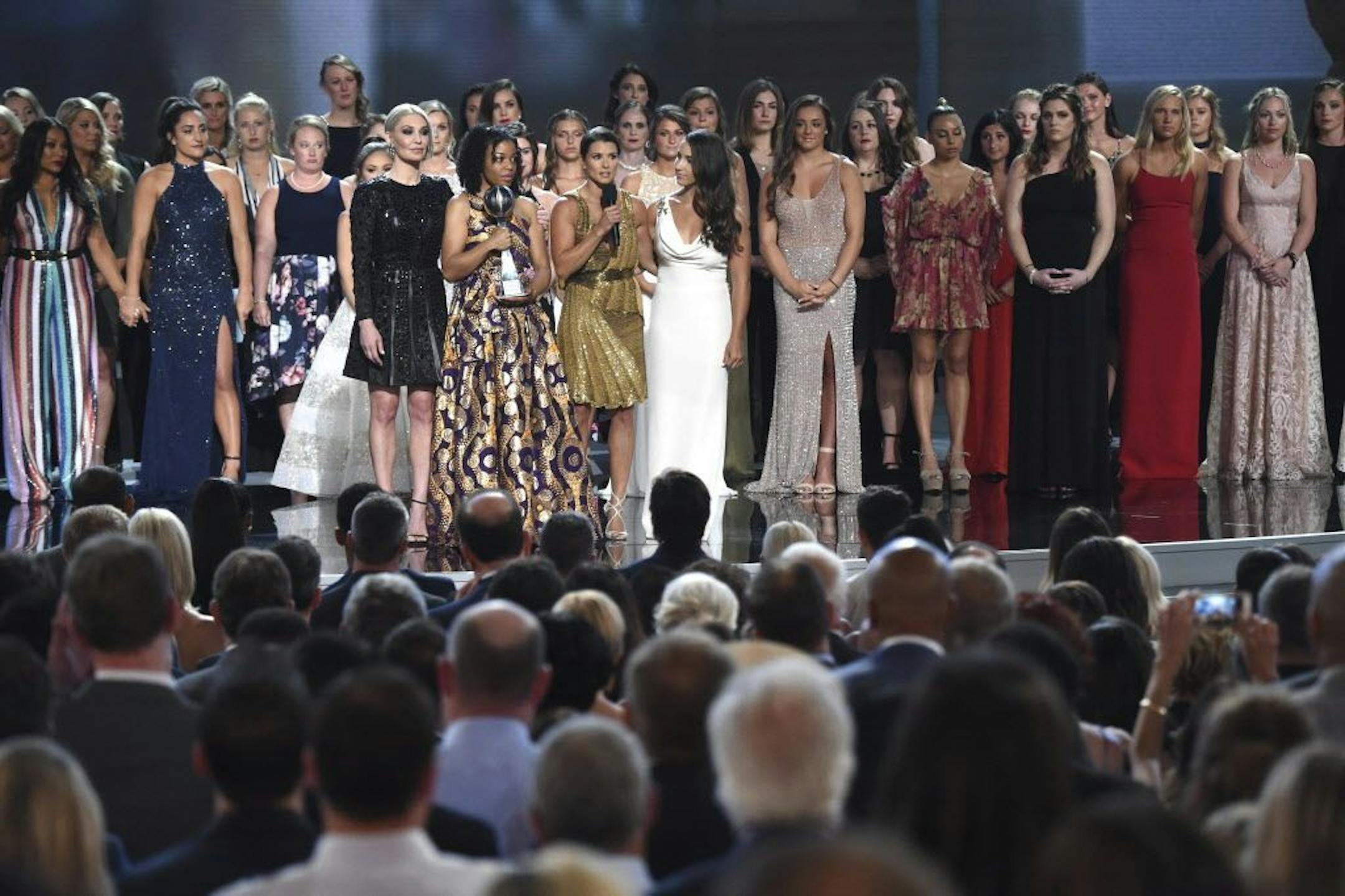 Host Danica Patrick appears with the winners of the Arthur Ashe Award for Courage, at the ESPY Awards at the Microsoft Theater on Wednesday, July 18, 2018, in Los Angeles. More than 140 survivors of sexual abuse by a former team doctor for USA Gymnastics and Michigan State University joined hands on stage to be honored with the award.