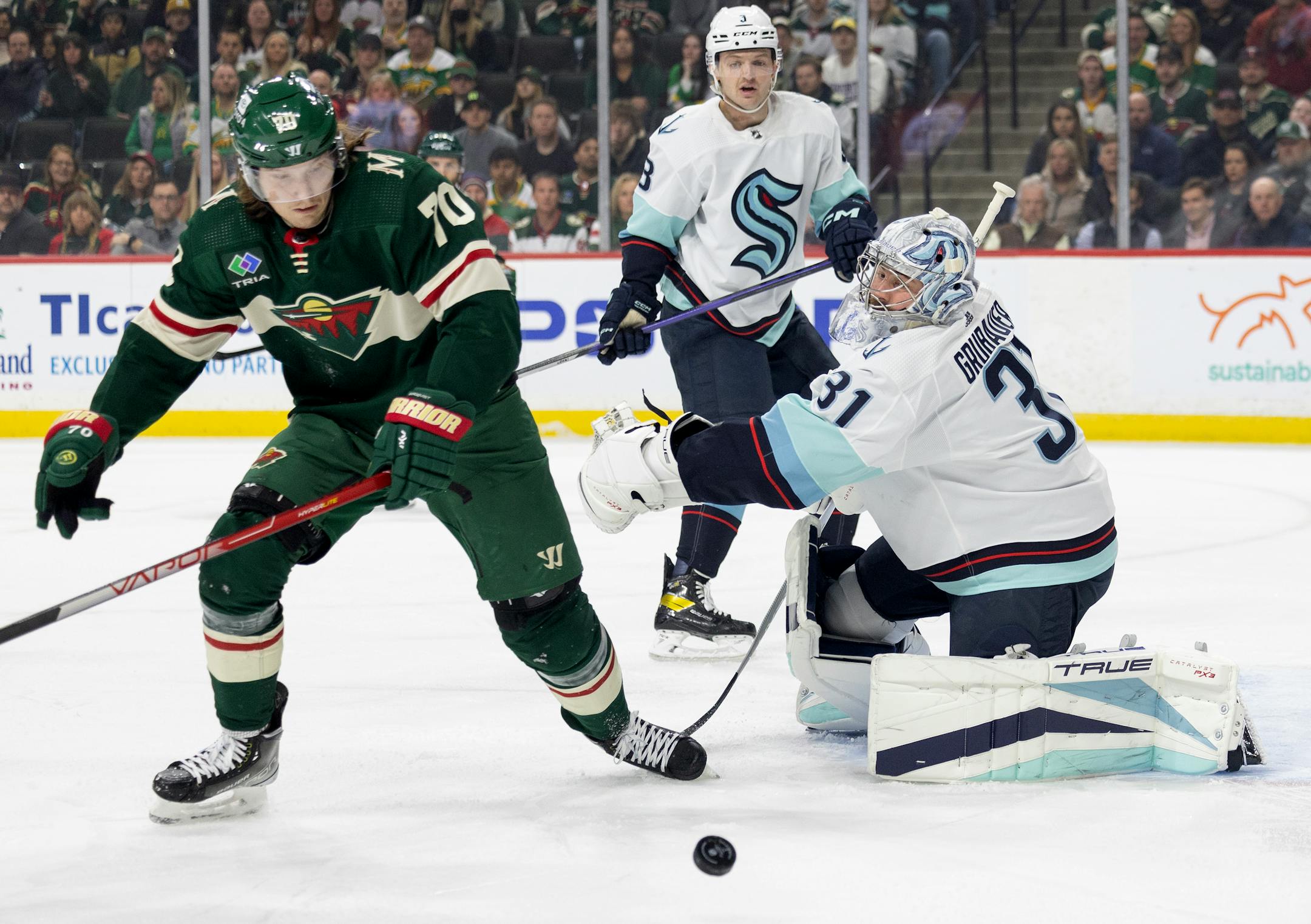 Oskar Sundqvist (70) of the Minnesota Wild and Seattle Kraken Philipp Grubauer (31) in the first period.