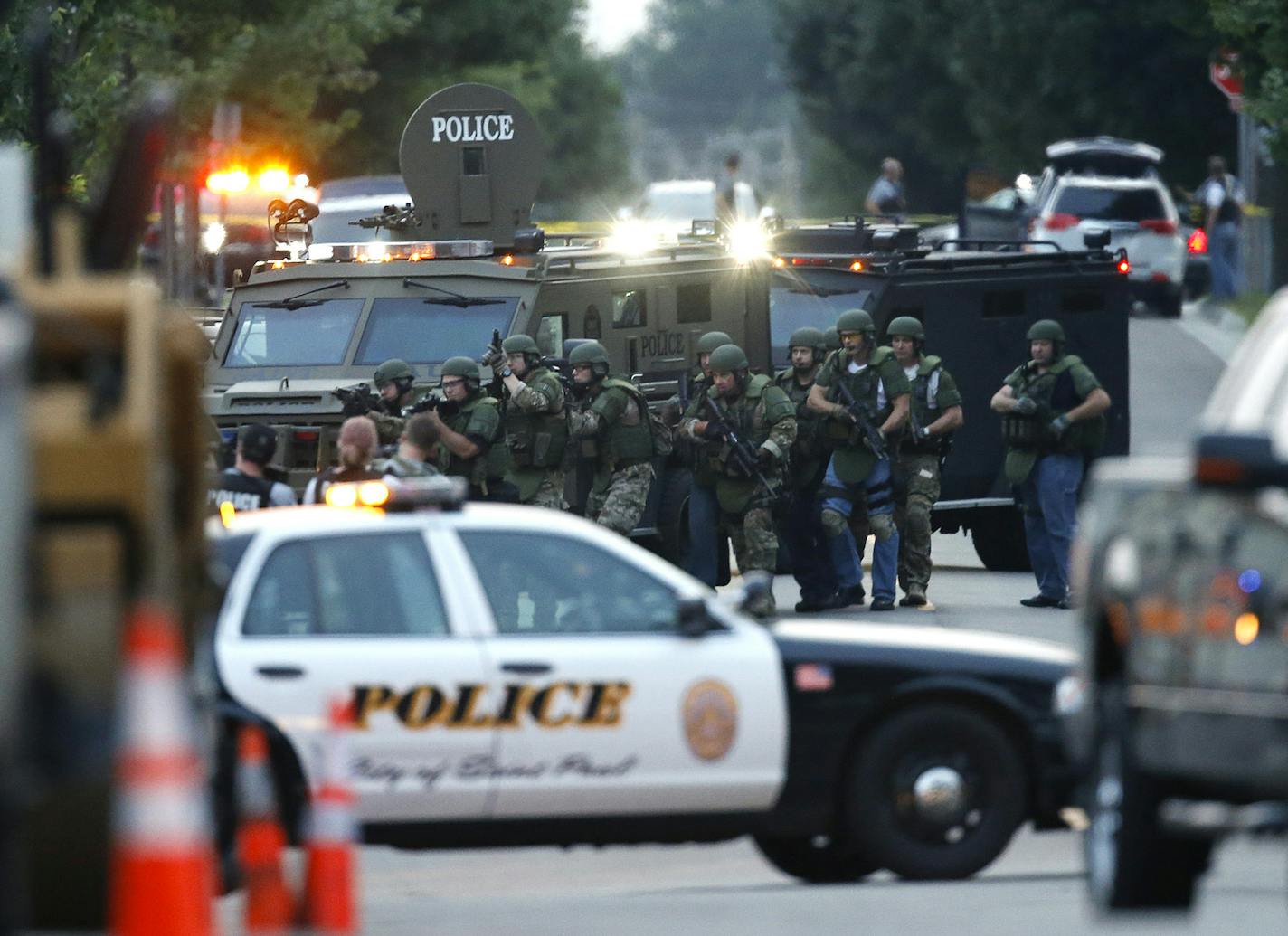 A SWAT team approached the house on Sycamore St. near Jackson St. in St. Paul Wednesday evening. ] JEFF WHEELER &#x201a;&#xc4;&#xa2; jeff.wheeler@startribune.com St. Paul Police apprehended the suspect in the shooting of a police officer at a house on Sycamore St. in St. Paul Wednesday night, July 30, 2014. ORG XMIT: MIN1407302148310412