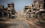 FILE - In this Saturday, Oct. 22, 2011 file photo, a general view of buildings ravaged by fighting in Sirte, Libya. From east and west, the forces of 