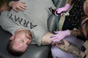 Steve Major, an Iraq War Veteran got his purple heart tattooed on his right bicep by Misty Chastain. On his arm were the Army coordinates where he was