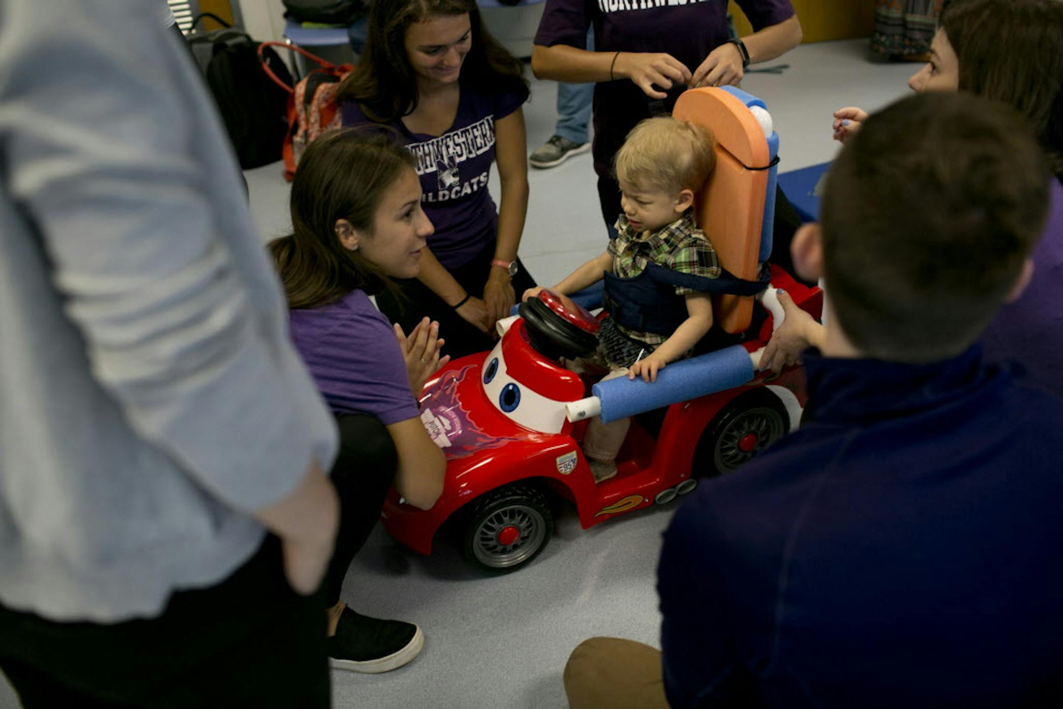 Spencer Oswald, 2, sits in a model car he is being fitted for by Northwestern University physical therapy students on Friday, June 15, 2018 in Chicago, Ill. The students are retrofitting the internal electronics of Fisher-Price Hot Wheels toys to be driven by five children who can't walk or have other limited mobility.