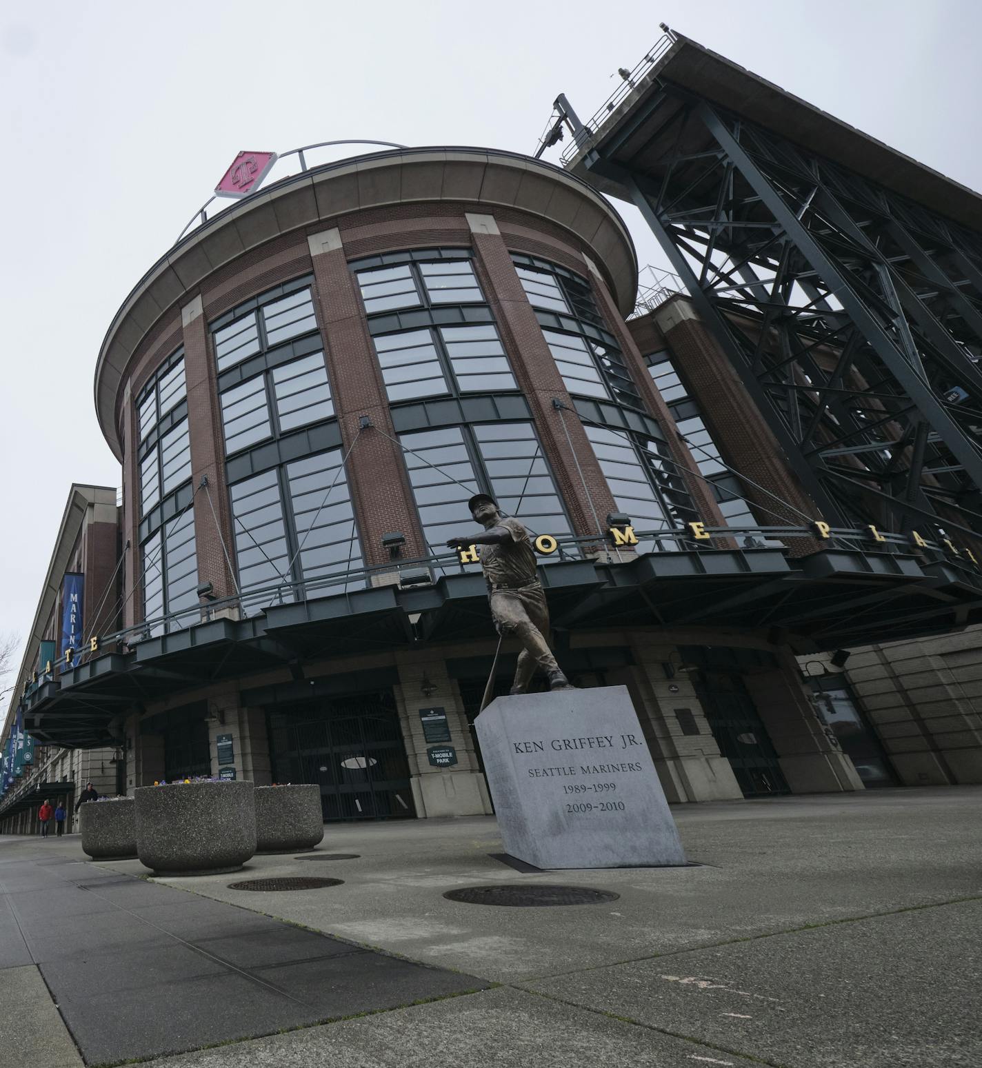 A Ken Griffey Jr. statue sits outside T-Mobile Park, Wednesday, March 11, 2020, in Seattle, where baseball's Seattle Mariners plays home games. In efforts to slow the spread of the COVID-19 coronavirus, Washington State Gov. Jay Inslee announced a ban on large public gatherings in three counties in the metro Seattle area. That decision impacts the Seattle Mariners, Seattle Sounders, and the XFL's Seattle Dragons home games. (AP Photo/Stephen Brashear)