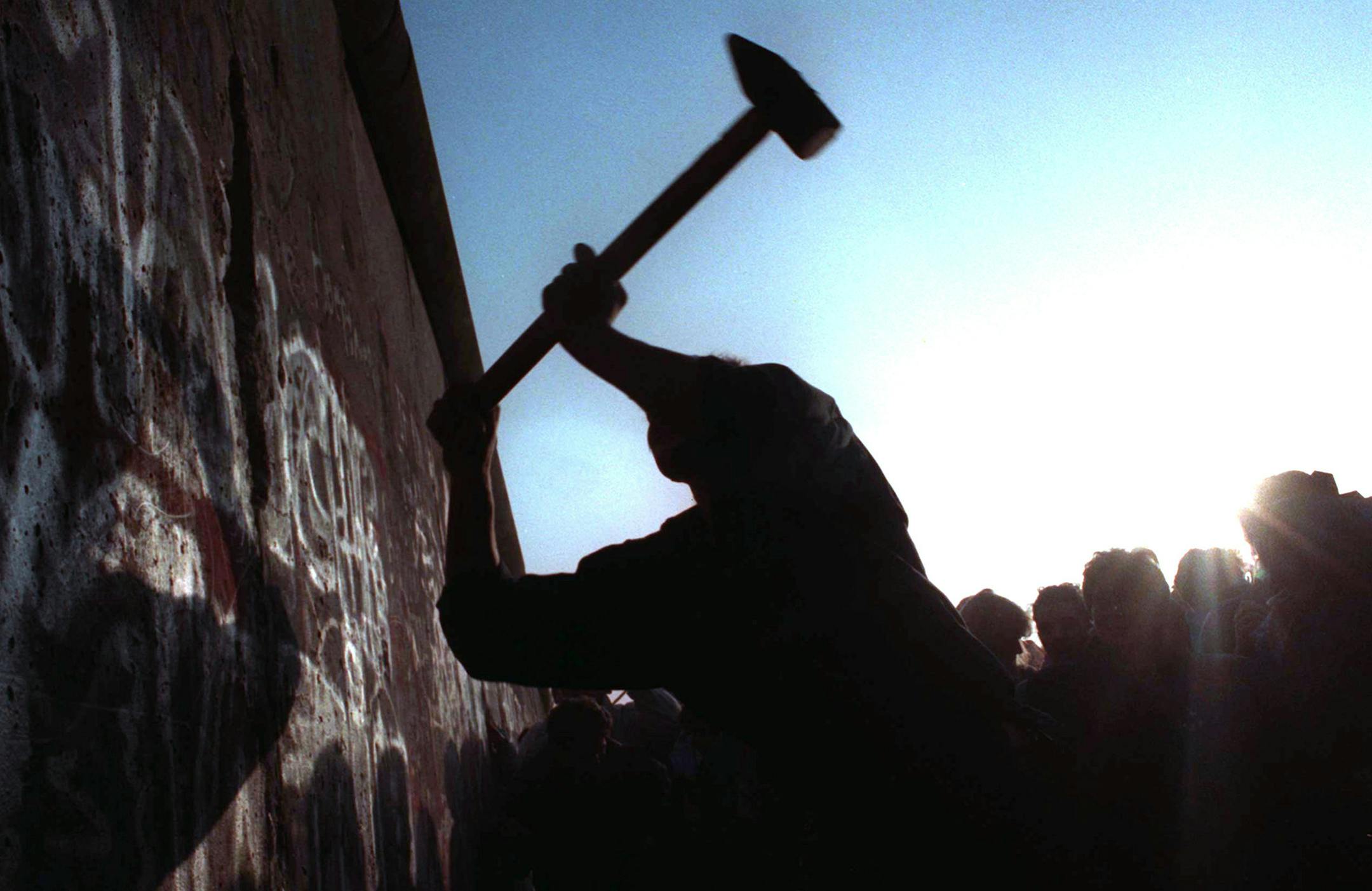 FILE - This Nov. 12, 1989 file photo shows a man hammering at the Berlin Wall, as the border barrier between East and West Germany was torn down after 28 years. Monday, Nov. 9, 2009 marks the 20th anniversary of the fall of the Berlin Wall. (AP Photo/John Gaps III, File)