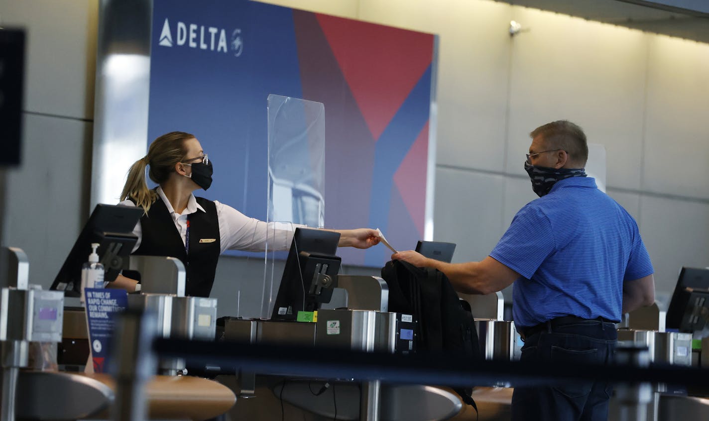 Delta Air Lines says it has a way to keep its front-line ground workers and flight attendants employed without furloughs. The airline may need to reduce its pilot corps. File photo of a Delta ticketing agent in Denver this summer.