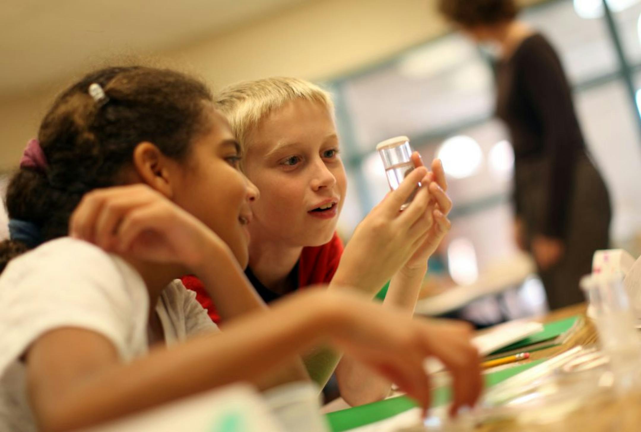 Fourth-graders Malia Pattison and Jack Wambolt looked closely at a rock immersed in vinegar during an Ignite science class at Oak Hills Elementary School in Lakeville, Minn., Wednesday, September 28, 2011. Ignite is a new program in the Lakeville school district puts highly gifted kids in their own classrooms all day.