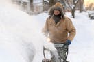 Jim Adam blows snow in front of his house on West Lewis Street in Mankato, Minn.
