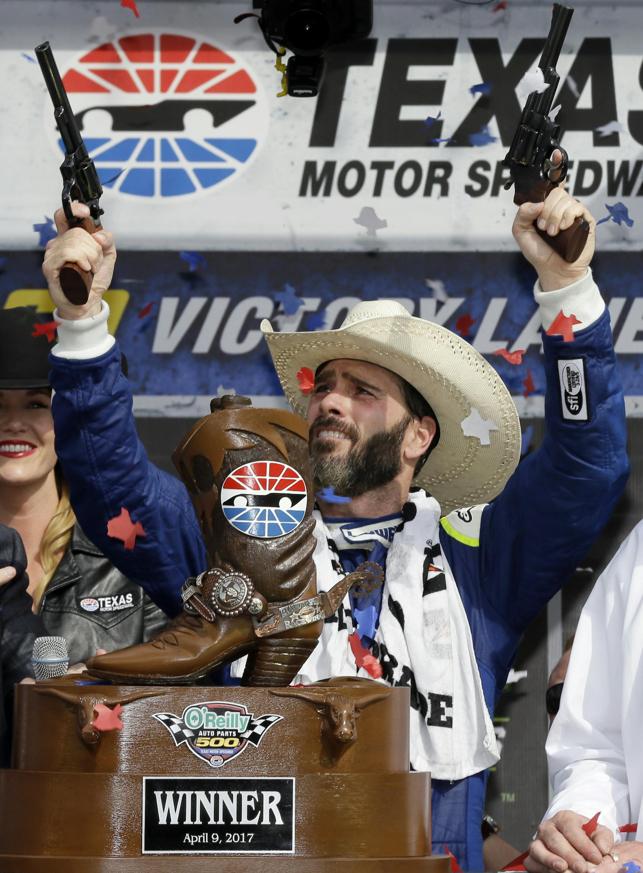 Jimmie Johnson fires commemorative pistols in victory lane after winning the NASCAR Cup Series auto race at Texas Motor Speedway in Fort Worth, Texas, Sunday, April 9, 2017. (AP Photo/Tony Gutierrez)