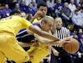 Northwestern guard Tre Demps, center, controls the ball between Minnesota forward Charles Buggs, left, and guard Nate Mason during the first half of a