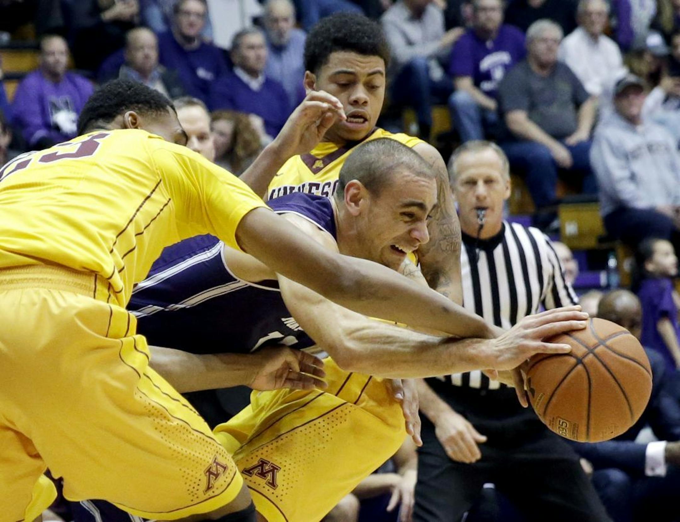 Northwestern guard Tre Demps, center, controls the ball between Minnesota forward Charles Buggs, left, and guard Nate Mason during the first half of an NCAA college basketball game on Thursday, Feb. 4, 2016, in Evanston, Ill.