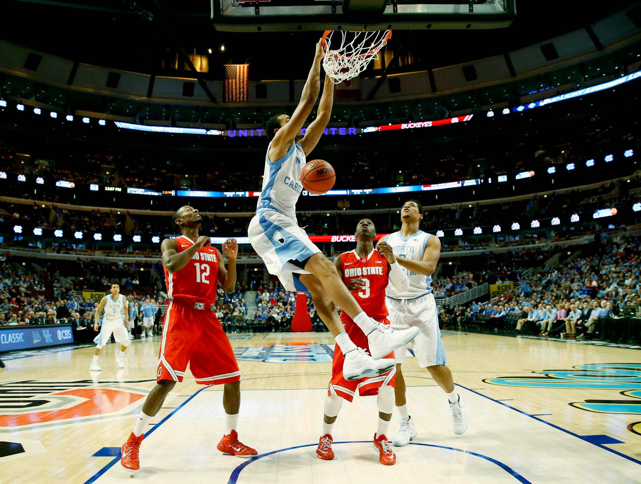 North Carolina forward Brice Johnson (11) dunks as forward Kennedy Meeks (3) and Ohio State forward Sam Thompson (12), guard Shannon Scott (3) look on during the first half of an NCAA college basketball game in CBS Sports Classic on Saturday, Dec. 20, 2014, in Chicago. (AP Photo/Charles Rex Arbogast)