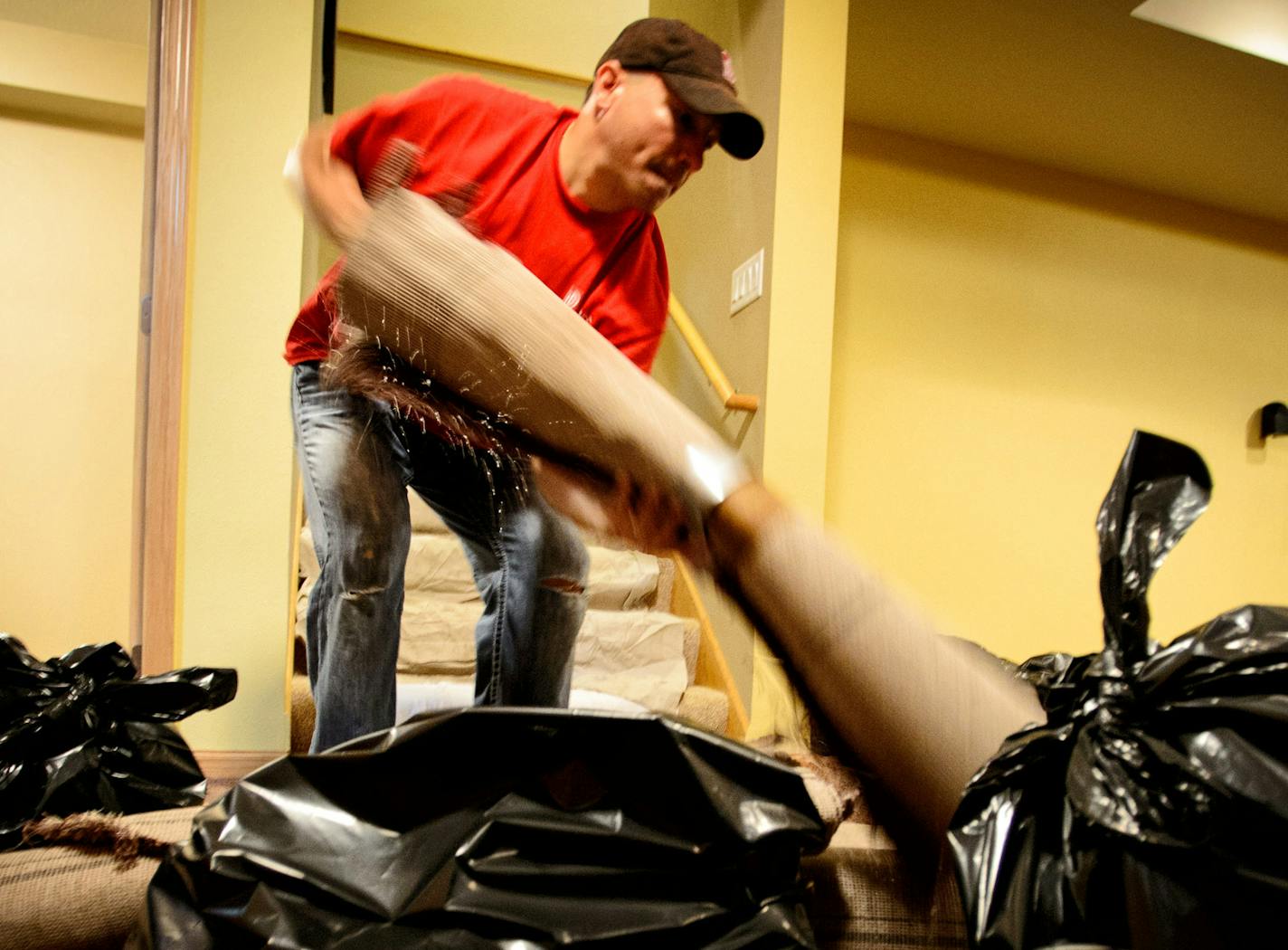 Bill Bentz of Paul Davis Emergency Services removed strips of soggy carpet from the home of Melany and Chase Sutton. The flooded basement was caused by overnight torrential rains around Mankato. Their sump pump failed. ] GLEN STUBBE * gstubbe@startribune.com Wednesday June 18, 2014 EDS, Melany is cq