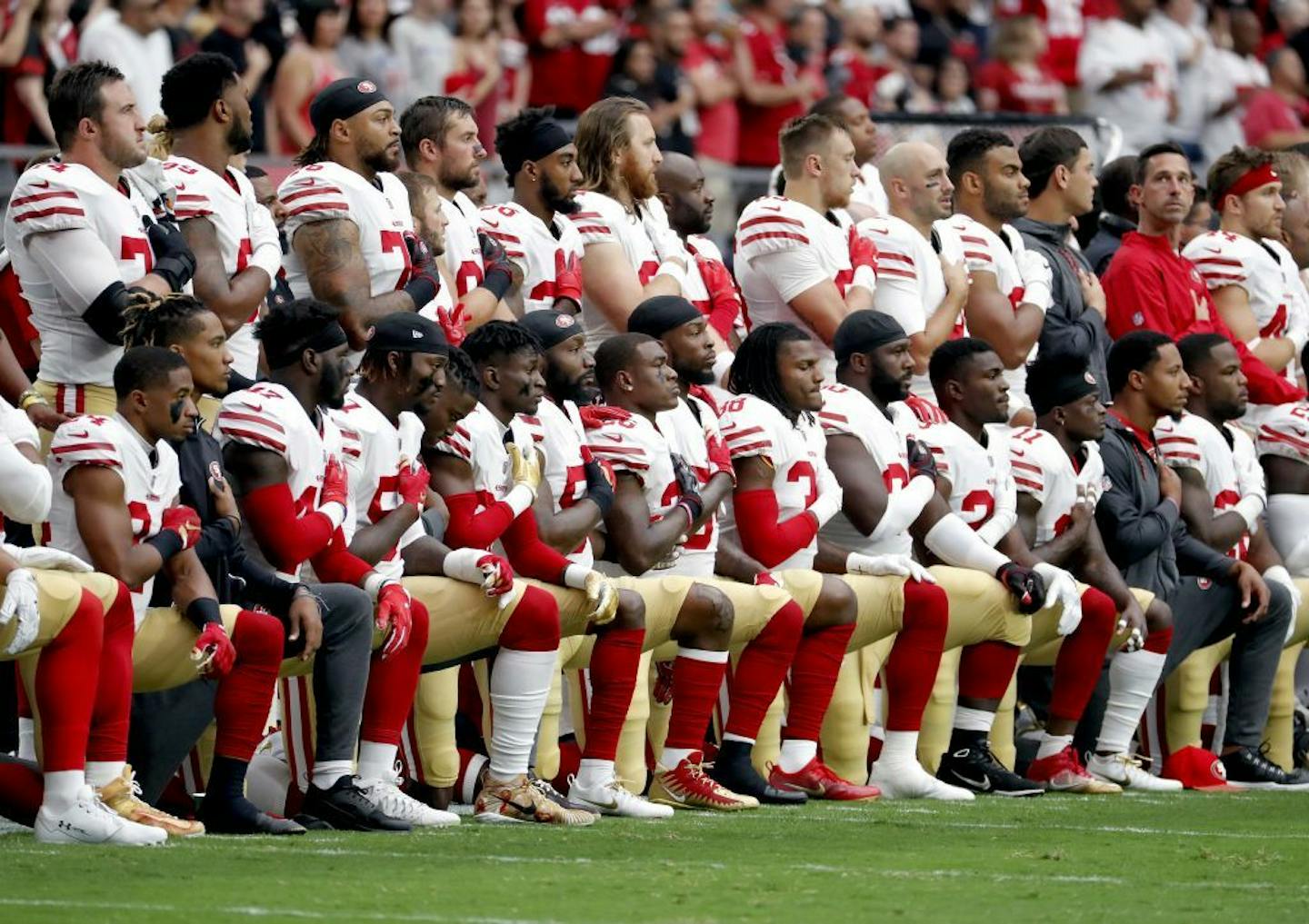 Members of the San Francisco 49ers kneel during the national anthem as others stand during the first half of an NFL football game against the Arizona Cardinals, Sunday, Oct. 1, 2017, in Glendale, Ariz.