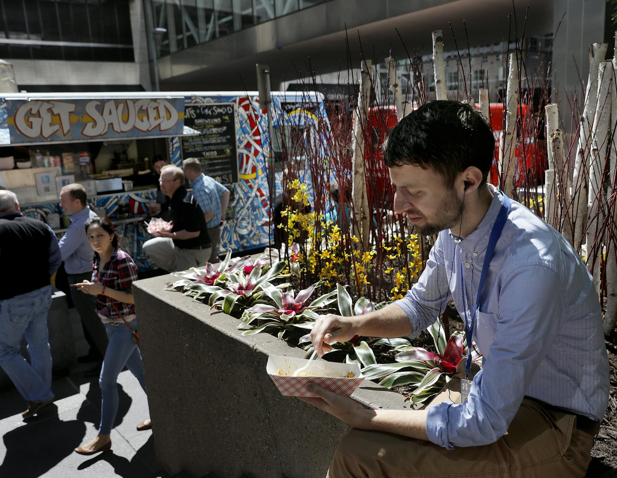 A planter near the Canadian Pacific Plaza provided a lunchtime perch for Spencer Agnew to enjoy a taco from a food truck.