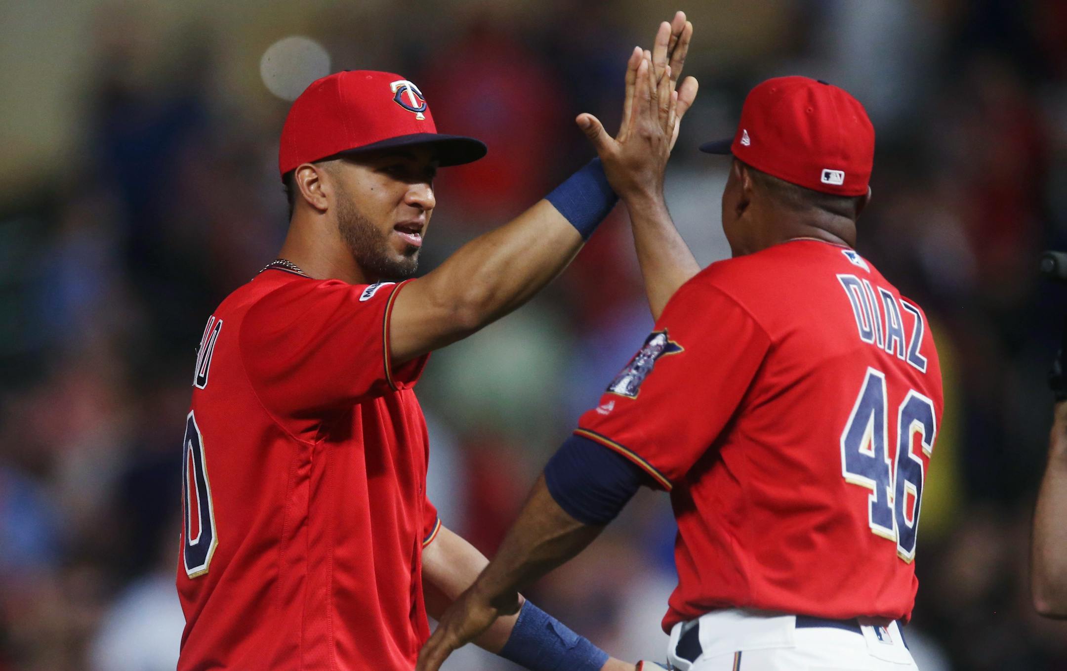 Eddie Rosario, left, goes through the celebration line with a high-five from coach Tony Diaz after the Twins defeated the Oakland Athletics 6-3