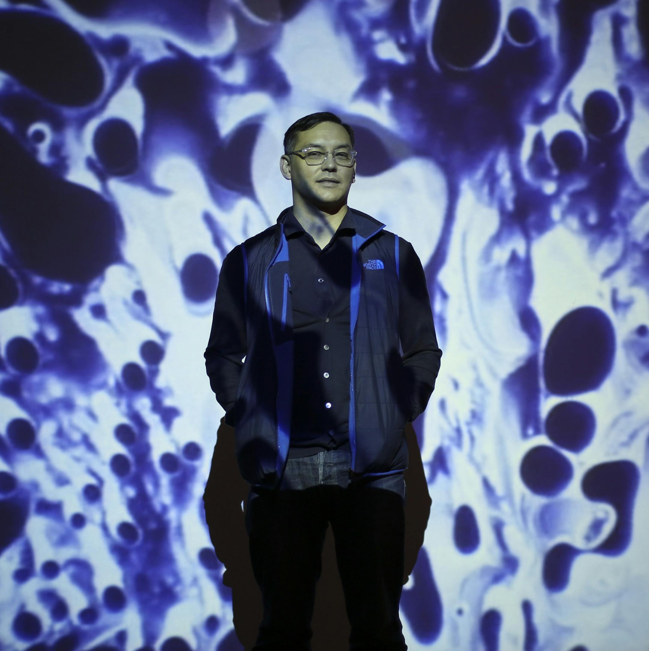 Curator Andrew Blauvelt bathed in one of the Boyle Family films in the Psychedelic Room of the show “Hippie Modernism: The Struggle for Utopia,” opening Friday night at Walker Art Center.