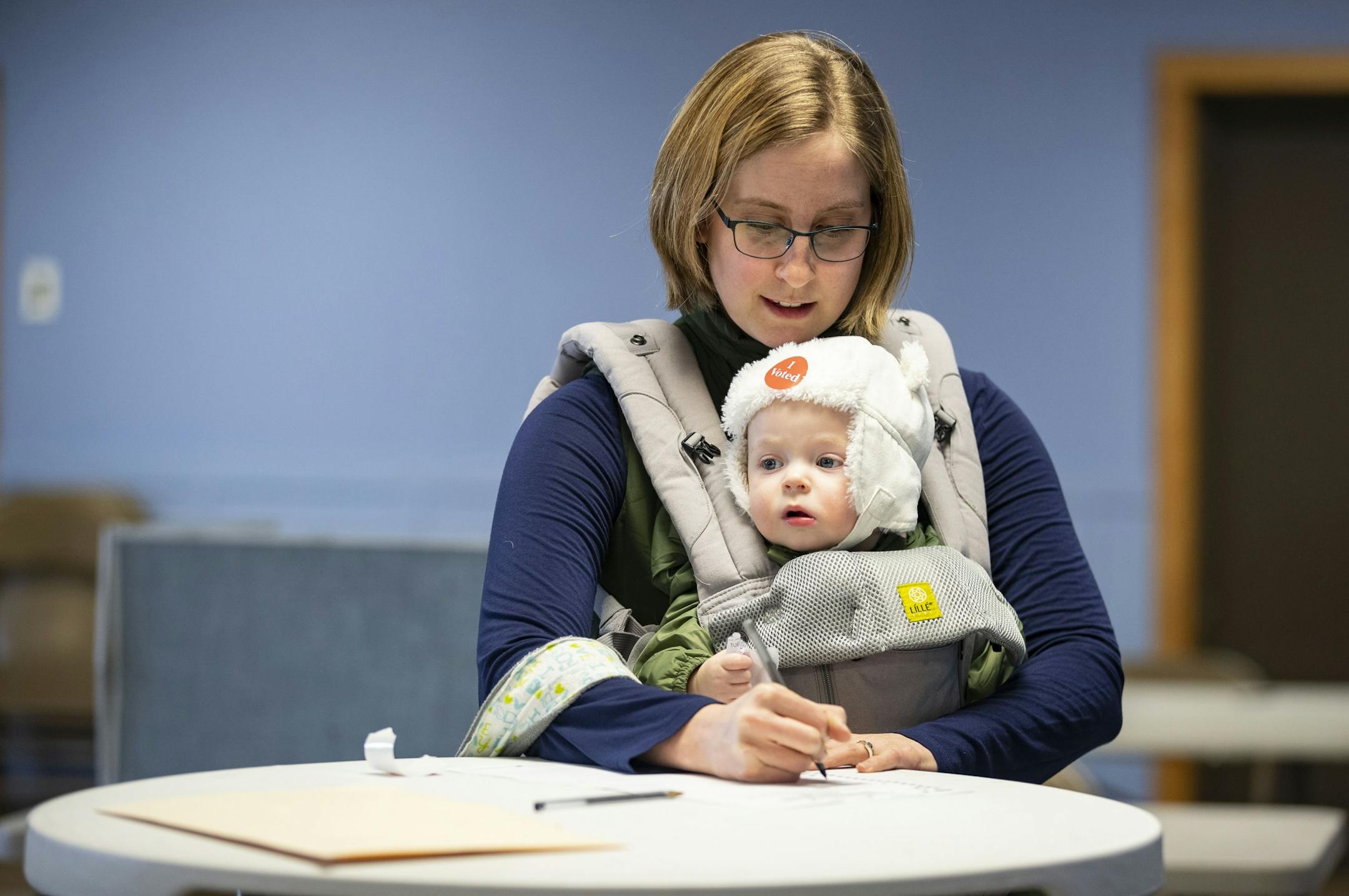 Caralyn Kieper filled out her ballot while carrying her 1-year-old daughter, Elliet, at Peace United Church of Christ in Duluth's 15th precinct on Tuesday.