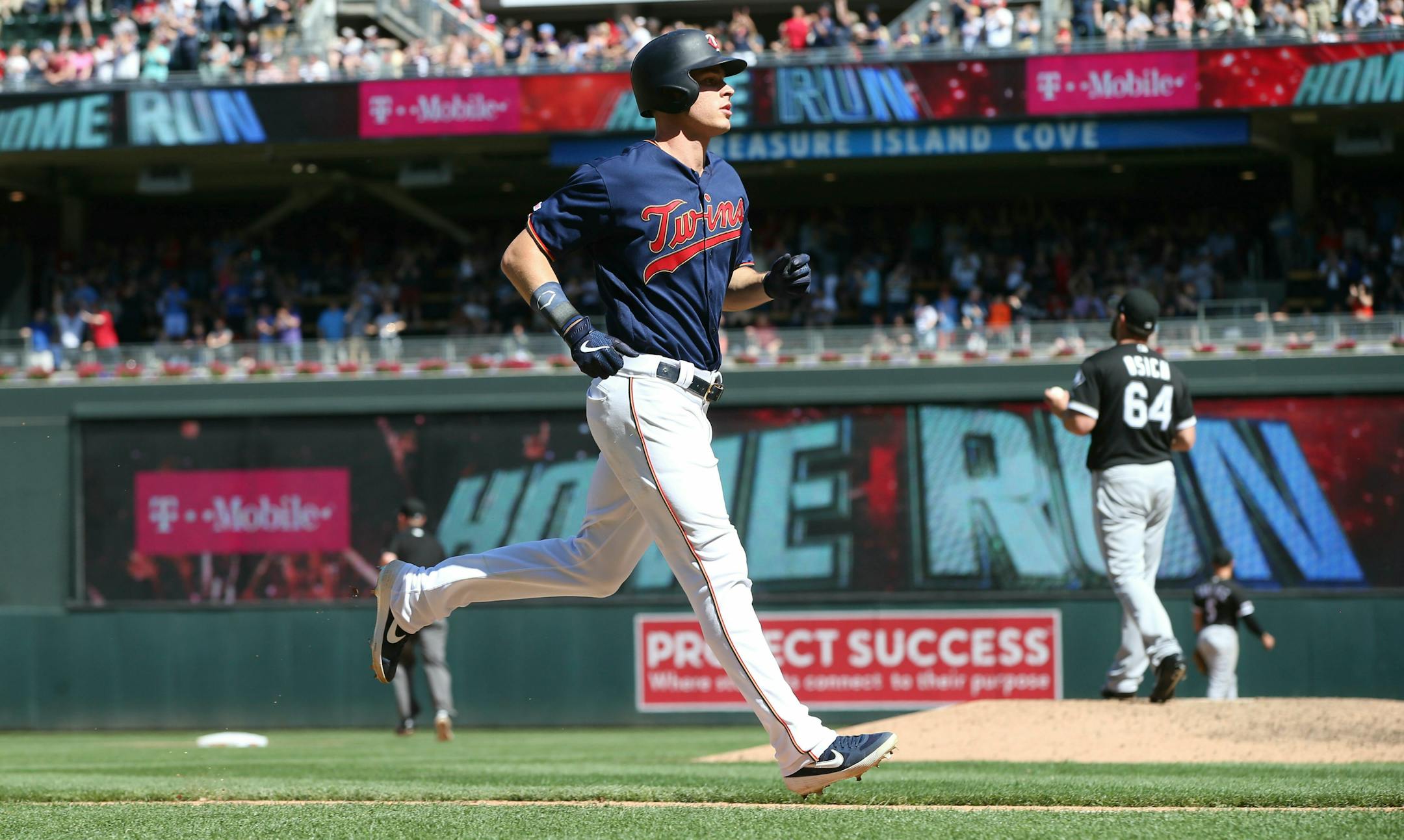 Minnesota Twins' Max Kepler, left, jogs home on his three-run home run off Chicago White Sox pitcher Josh Osich, right, in the seventh inning of a baseball game Sunday, May 26, 2019, in Minneapolis. The Twins won 7-0. (AP Photo/Jim Mone)