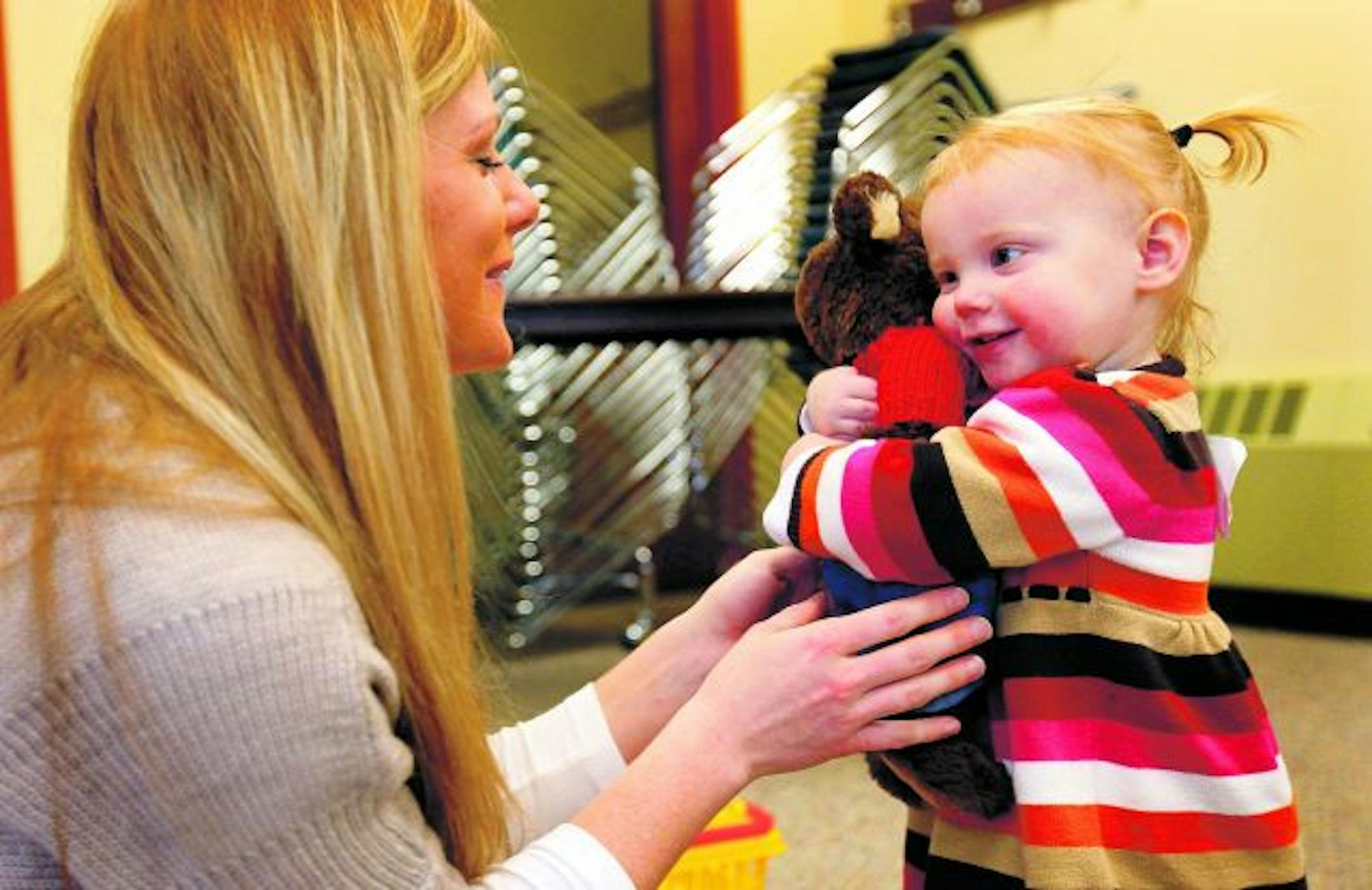 Lily Van Hecke, 17 months, hugged a stuffed bear with mother Jennifer next to her.