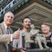 In this Monday. Sept. 9, 2013 photo, sculpture Rick Harney, center, holds a scale model of a sculpture of famed film critic Roger Ebert in front of th