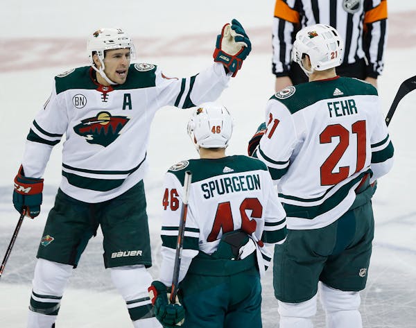 The Wild's Zach Parise (11), Jared Spurgeon (46) and Eric Fehr (21) celebrate a goal against the Winnipeg Jets during the third period Saturday.
