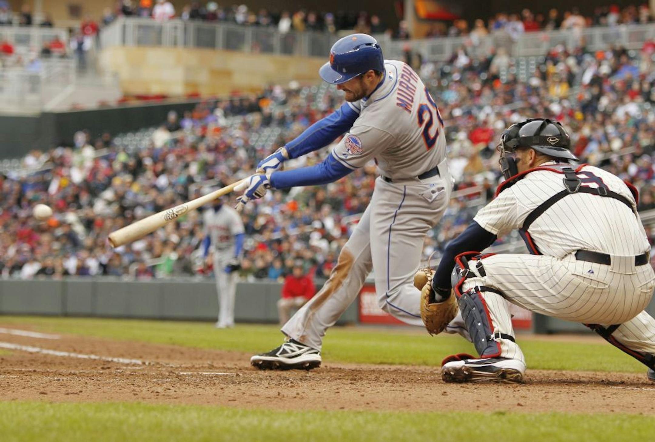 New York Mets' Daniel Murphy (28) hits an RBI single against Minnesota Twins starting pitcher Scott Diamond as Twins' Ryan Doumit (9) catches during the fifth inning of a baseball game Saturday, April 13, 2013, in Minneapolis.