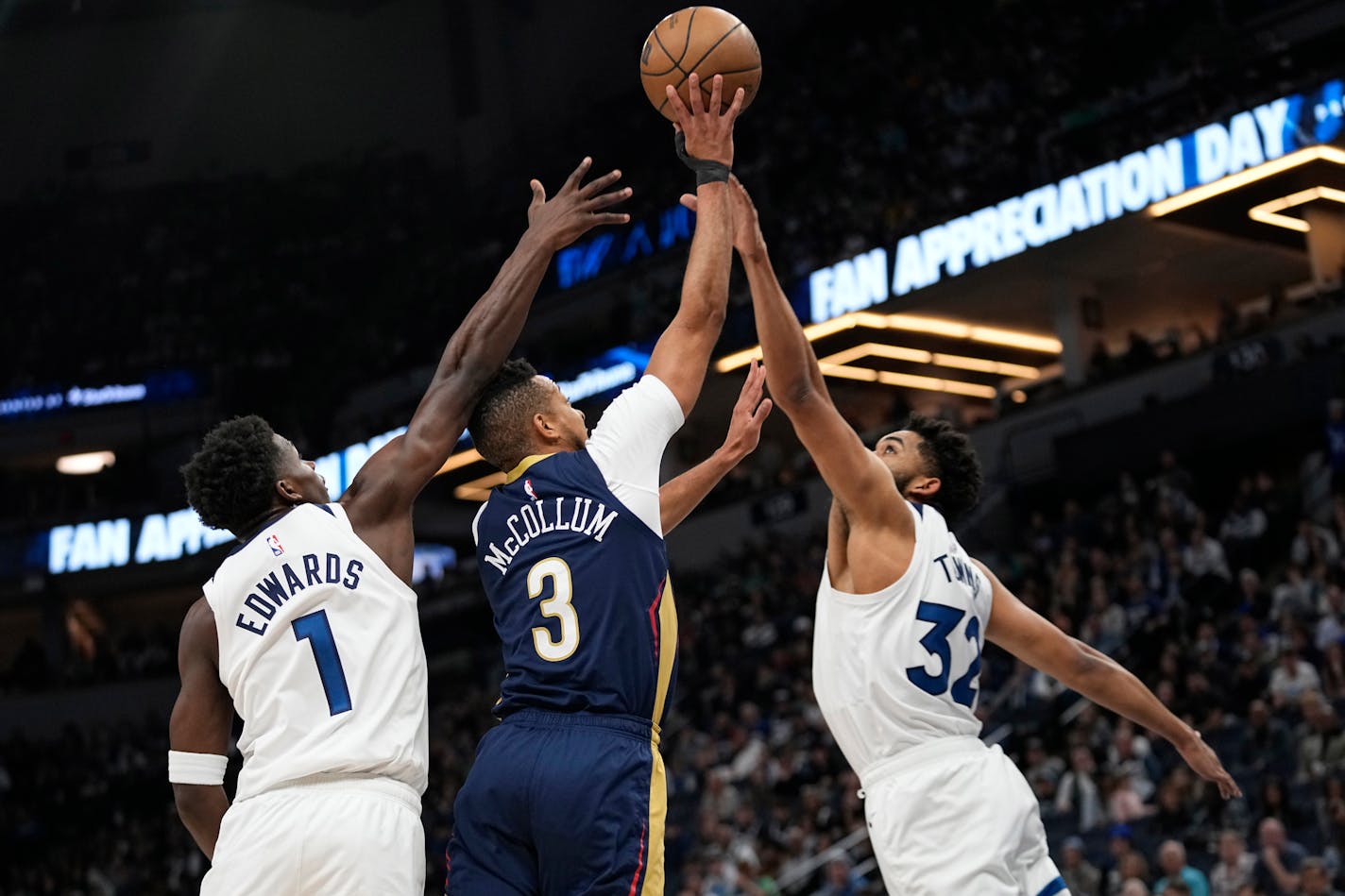 New Orleans Pelicans guard CJ McCollum (3) shoots against Minnesota Timberwolves guard Anthony Edwards (1) and center Karl-Anthony Towns during the first half of an NBA basketball game, Sunday, April 9, 2023, in Minneapolis. (AP Photo/Abbie Parr)