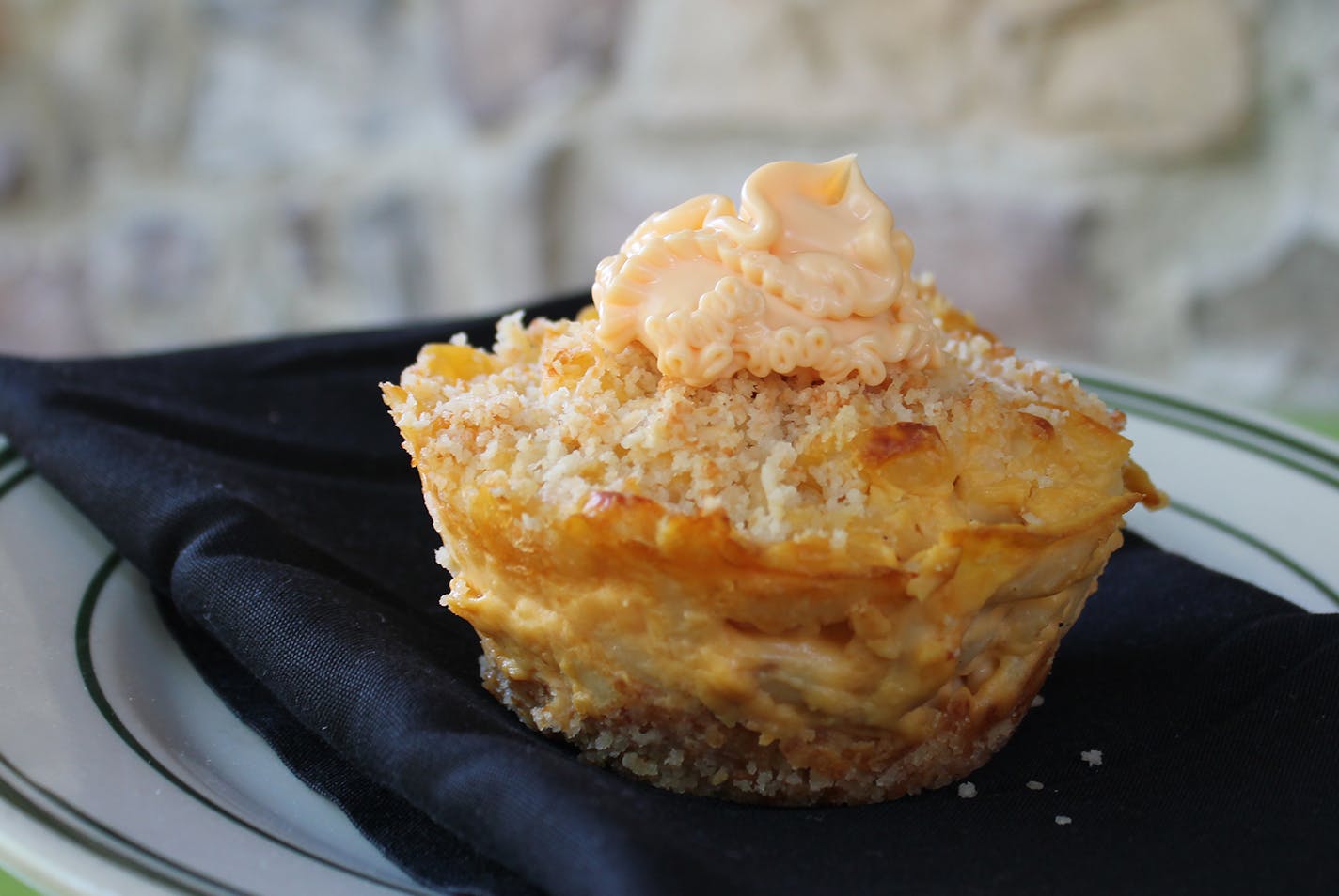 Mac & Cheese Cupcake: Mac & cheese nestled in a breadcrumb crust, then sprinkled with breadcrumbs and frosted with a dollop of Cheez Whiz. Find it at LuLu's Public House located at West End Market, west side, south of Schilling Amphitheater.