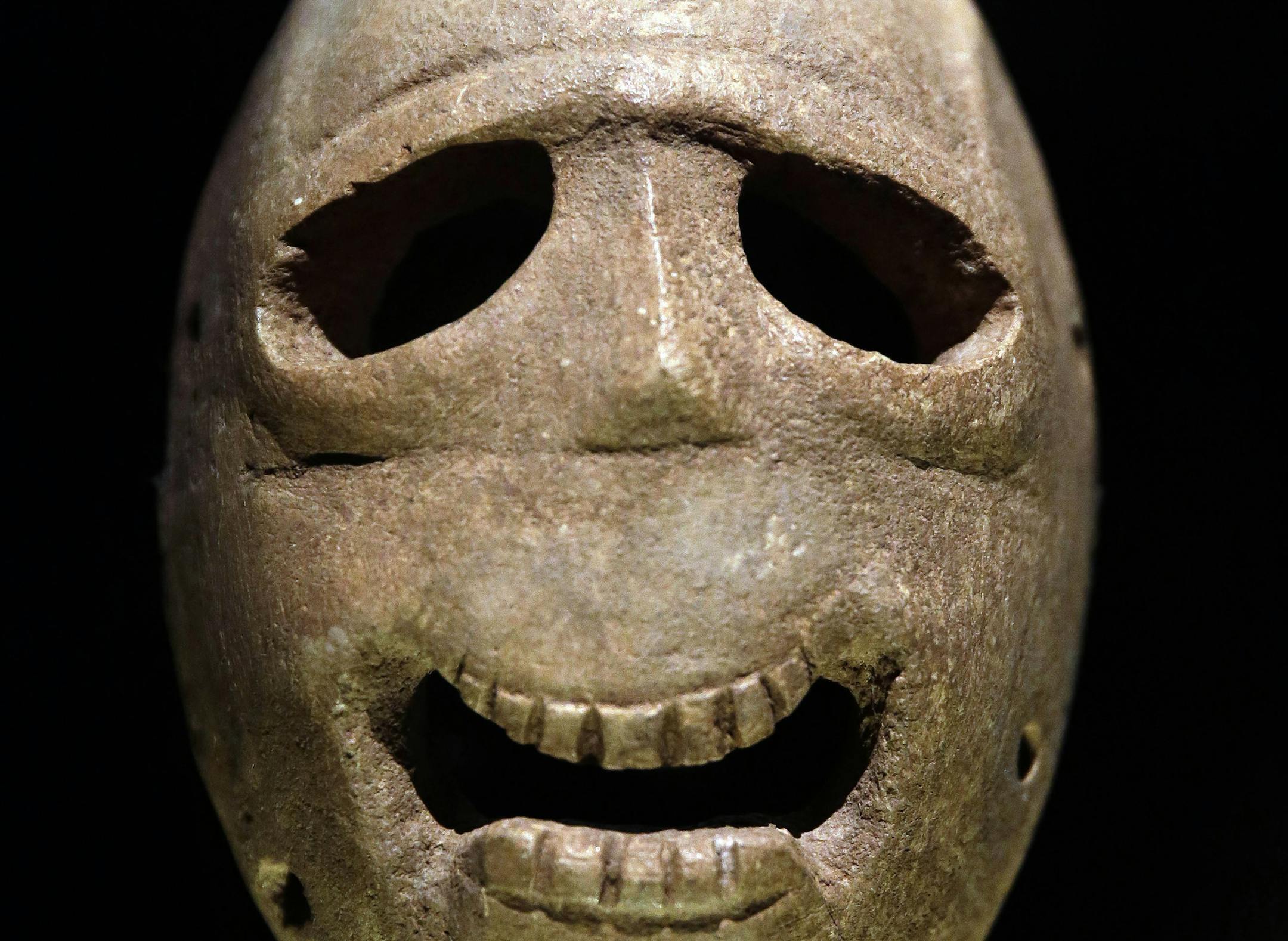 In this Monday, March 10, 2014 photo, a 9,000 year-old mask is on display at the Israel Museum in Jerusalem. The exhibition called "Face To Face" shows eleven stone masks, said to have been discovered in the Judean desert and hills near Jerusalem, which date back 9,000 years and offer a rare glimpse at some of civilization’s first communal rituals. (AP Photo/Tsafrir Abayov)