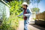 Master gardener Julie Ann Wegscheid pulls creeping bellflower as she walks around her neighborhood in St. Paul on Thursday. Wegscheid is on a mission 