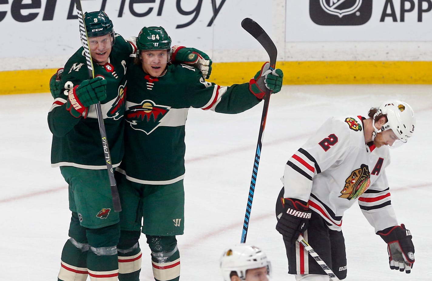 Chicago Blackhawks' Duncan Keith, right, skates away as Minnesota Wild's Mikko Koivu, left, and Mikael Granlund, both of Finland, celebrate Koivu's power play goal in the first period of an NHL hockey game, Saturday, Feb. 10, 2018, in St. Paul, Minn. (AP Photo/Jim Mone)