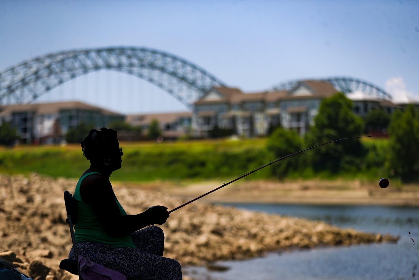 Jaqueline Davis fishes in the Wolf River Harbor underneath the A.W. Willis Bridge in Memphis on July 7, 2022. Davis has been coming to this spot for over a decade. Credit: Patrick Lantrip, Daily Memphian