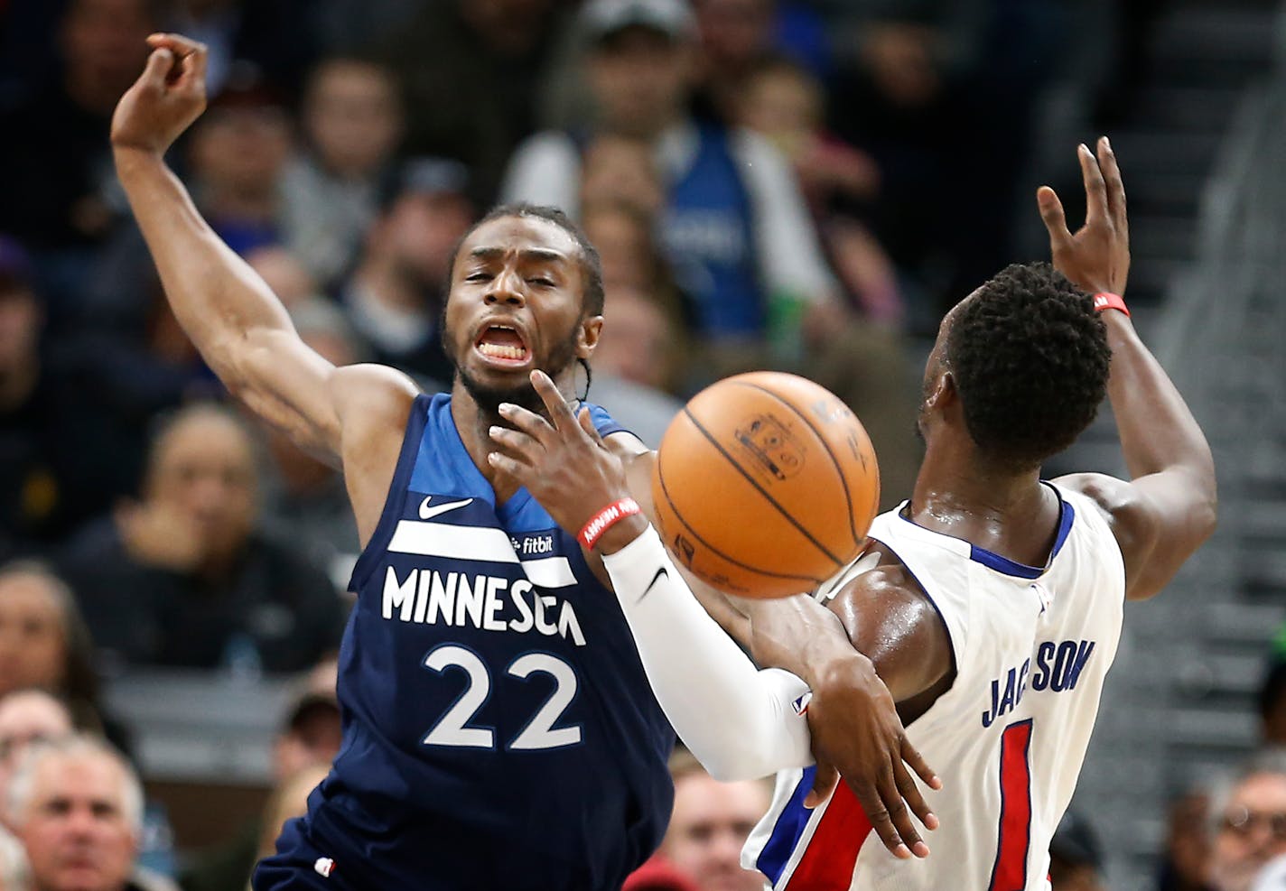 Timberwolves forward Andrew Wiggins (22) gets tangled up with Detroit guard Reggie Jackson (1) for a rebound during the first half.