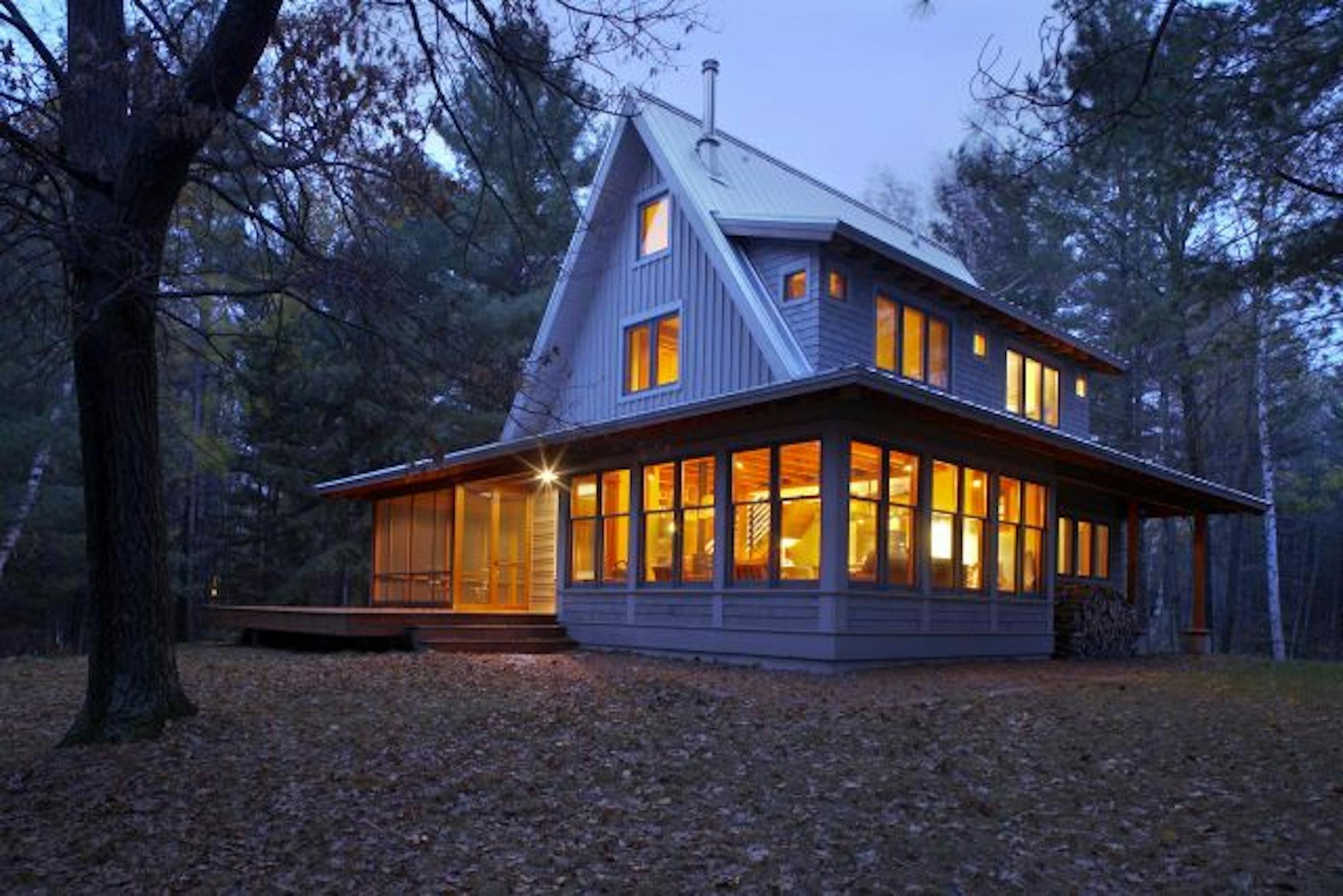 Marcelo Valdes's design combines a compact A-frame form with a low skirt roof that creates rooms that connect the indoors and outdoors.This is the lakeside view of the cabin.