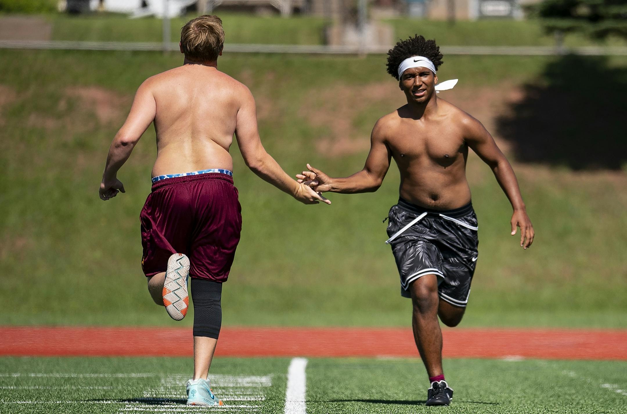 (Left) Jacob Plunkett slapped hands with Jayden Hester during the Denfeld football team's workout on Tuesday morning.