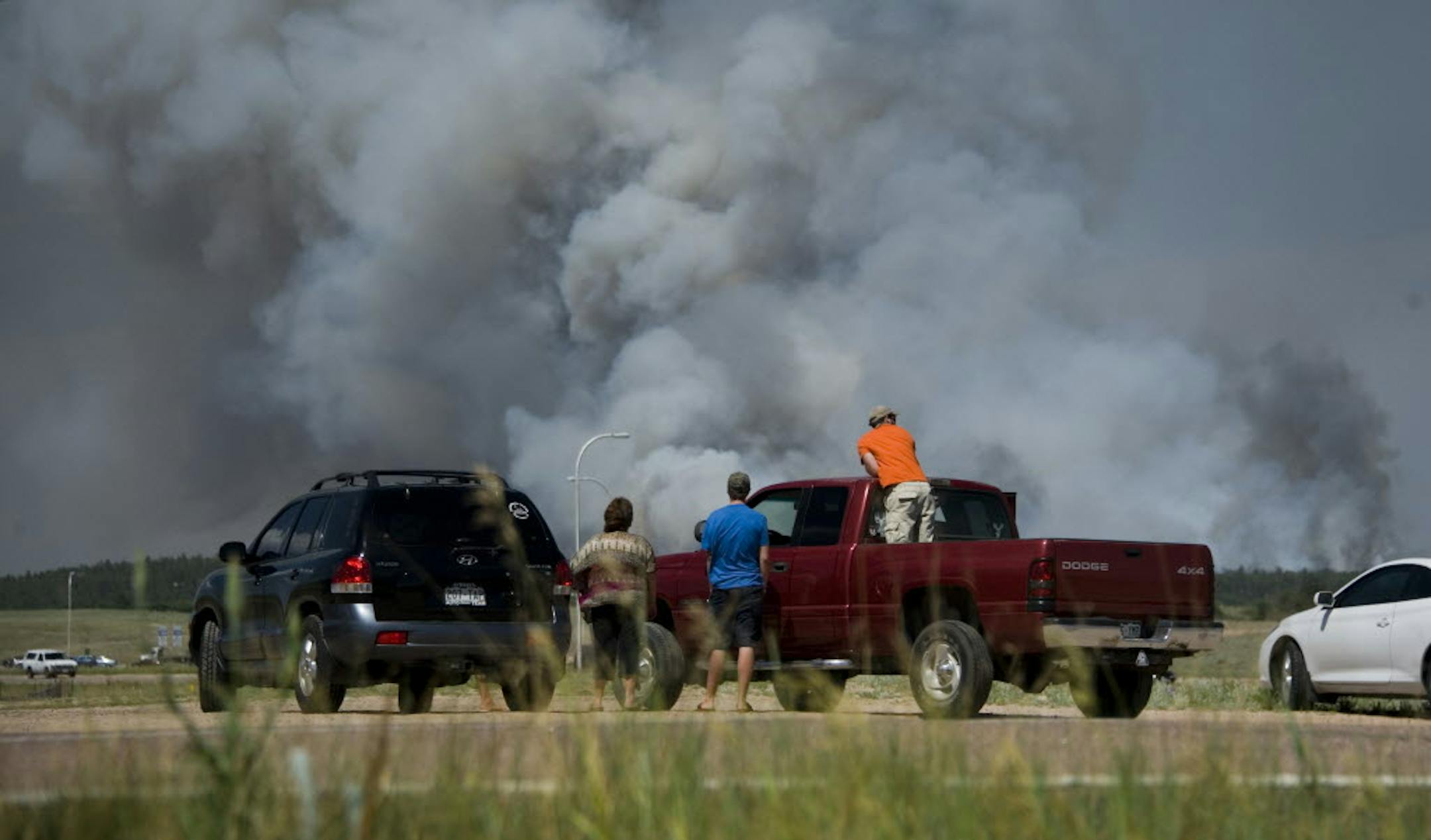 Motorists stop along Interquest Parkway in Colorado Springs, Colo. Tuesday, to watch the advance of a wildfire burning in Black Forest.