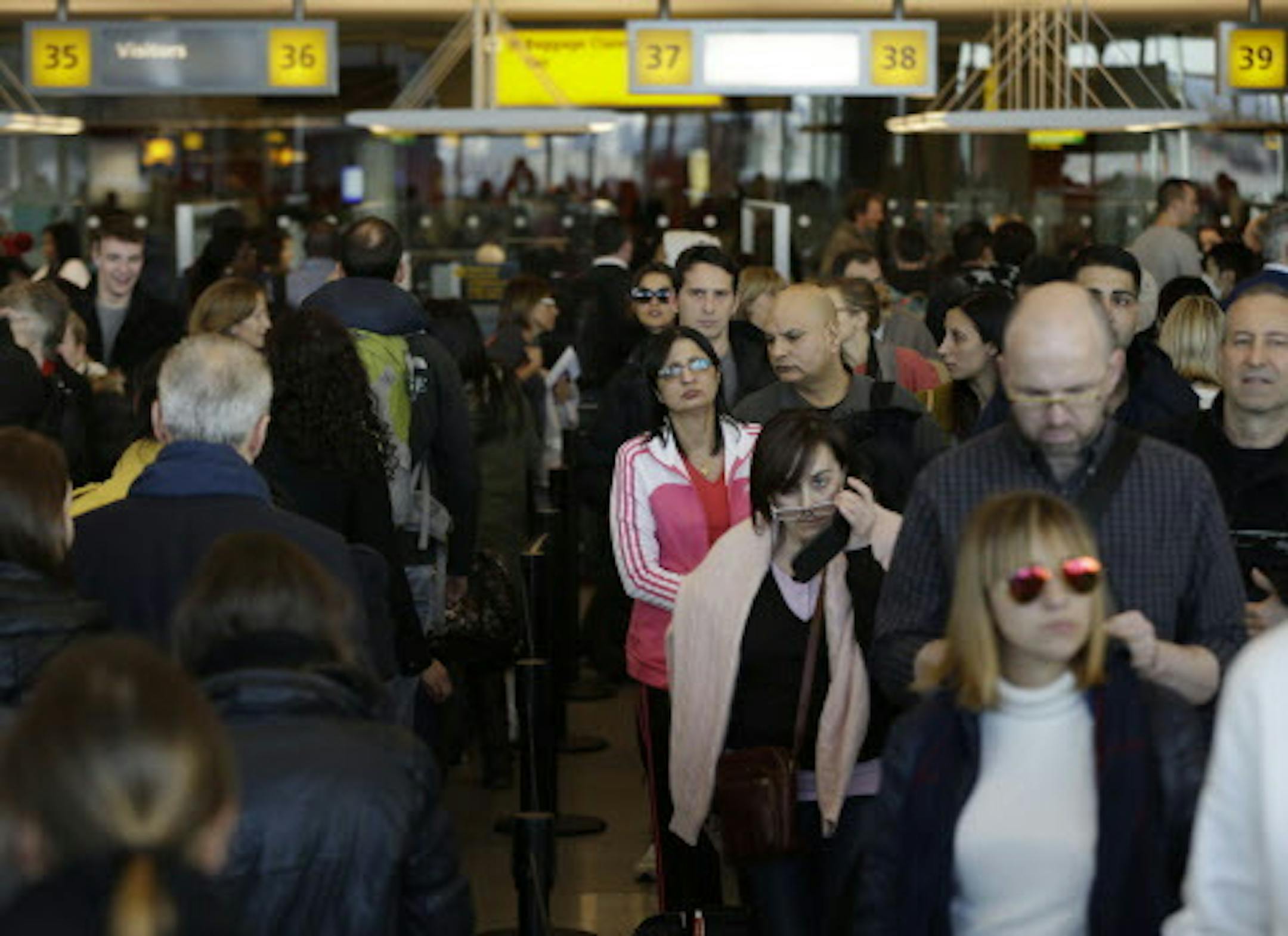 Travelers wait in a winding line to pass through customs and border control at John F. Kennedy Airport in New York, Monday, Nov. 25, 2013. A winter storm system blamed for at least 10 fatal accidents in the West and Texas threatens to dampen the Thanksgiving holiday for millions of Americans traveling this week. Nearly 300 American Airlines and American Eagle flights were canceled in and out of Dallas-Fort Worth International Airport on Monday due to the weather, spokeswoman Laura Masvidal said,