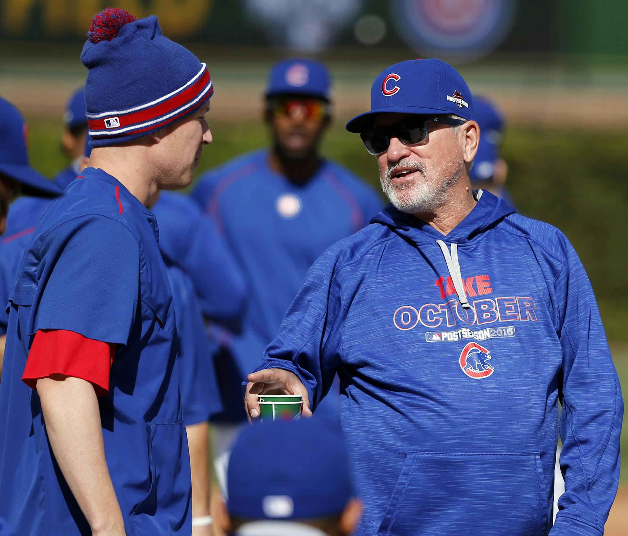 Chicago Cubs manager Joe Maddon, right, talks to Chris Coghlan during a team workout in preparation for Tuesday's Game 3 in baseball's National League Championship Series against the New York Mets, Monday, Oct. 19, 2015, in Chicago. (AP Photo/Charles Rex Arbogast)