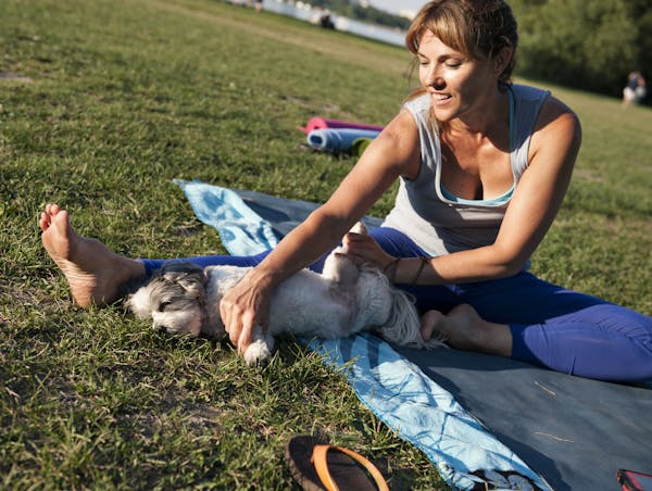 Tracy Miller stretches both her, and her dog Chloe during her Doga class at Lake Calhoun on July 24, 2013.
