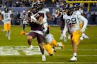 Minnesota running back Ky Thomas (8) runs away from West Virginia safety Alonzo Addae and safety Sean Mahone (29) during the first half of the Guarant