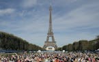 FILE - In this Saturday, Sept. 8, 2018 file photo, participants perform yoga in front of the Eiffel Tower as part of the sport event "La Parisienne", 