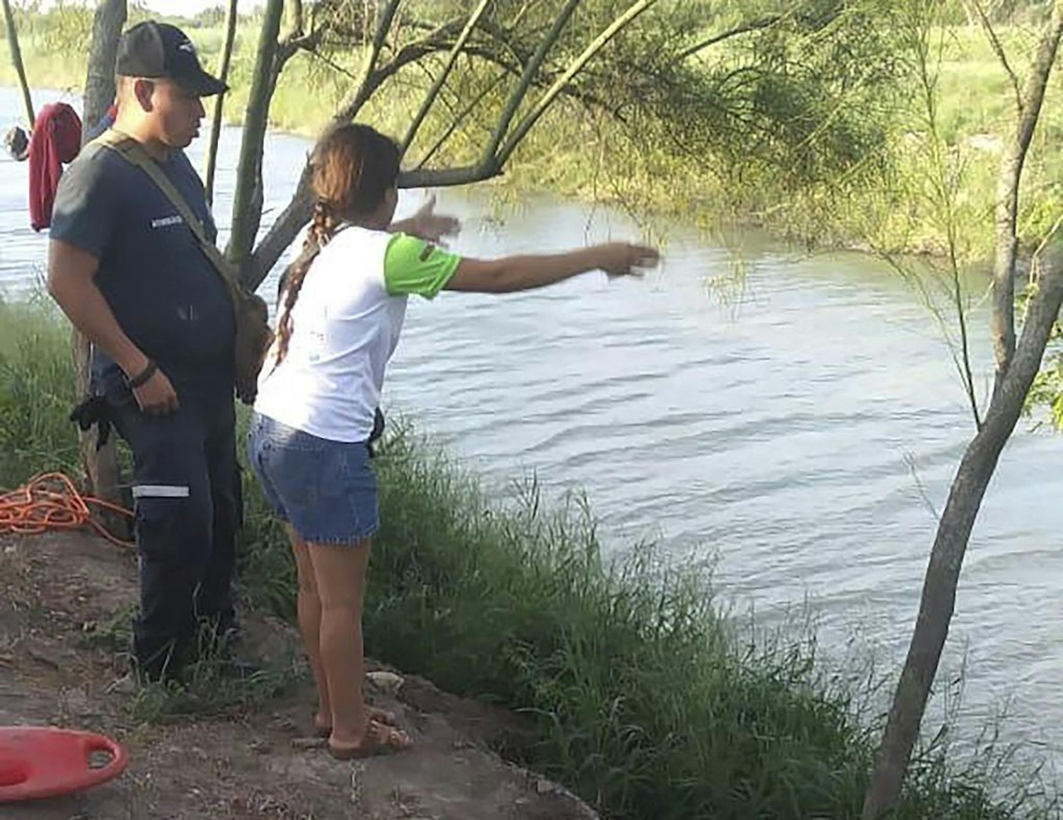 In this Sunday, June 23, 2019 photo, Tania Vanessa Ávalos of El Salvador speaks with Mexican authorities after her husband and nearly two-year-old daughter were swept away by the current in Matamoros, Mexico, while trying to cross the Rio Grande to Brownsville, Texas. Their bodies, the toddler still tucked into her father's shirt with her arm loosely draped around him, were discovered Monday morning several hundred yards from where they had tried to cross.