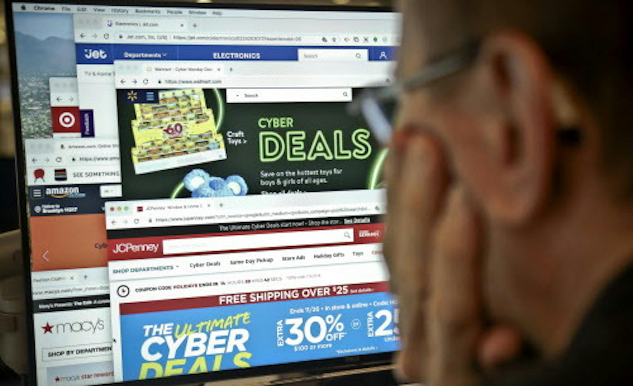 A journalist looks at a computer screen with webpages arranged to show Cyber Monday deals by various online retailers Monday Nov. 26, 2018, in New York. The physical rush of Black Friday and the armchair browsing of Cyber Monday are increasingly blending into one big holiday shopping event as more customers buy items online and pick them up at brick-and-mortar stores. (AP Photo/Bebeto Matthews)