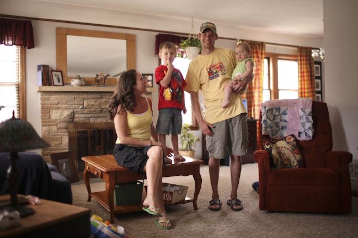 Nikki and Jesse Roggenbuck, shown with their two children in the rambler they bought last month, used two home buyer assistance programs to help qualify for a mortgage.