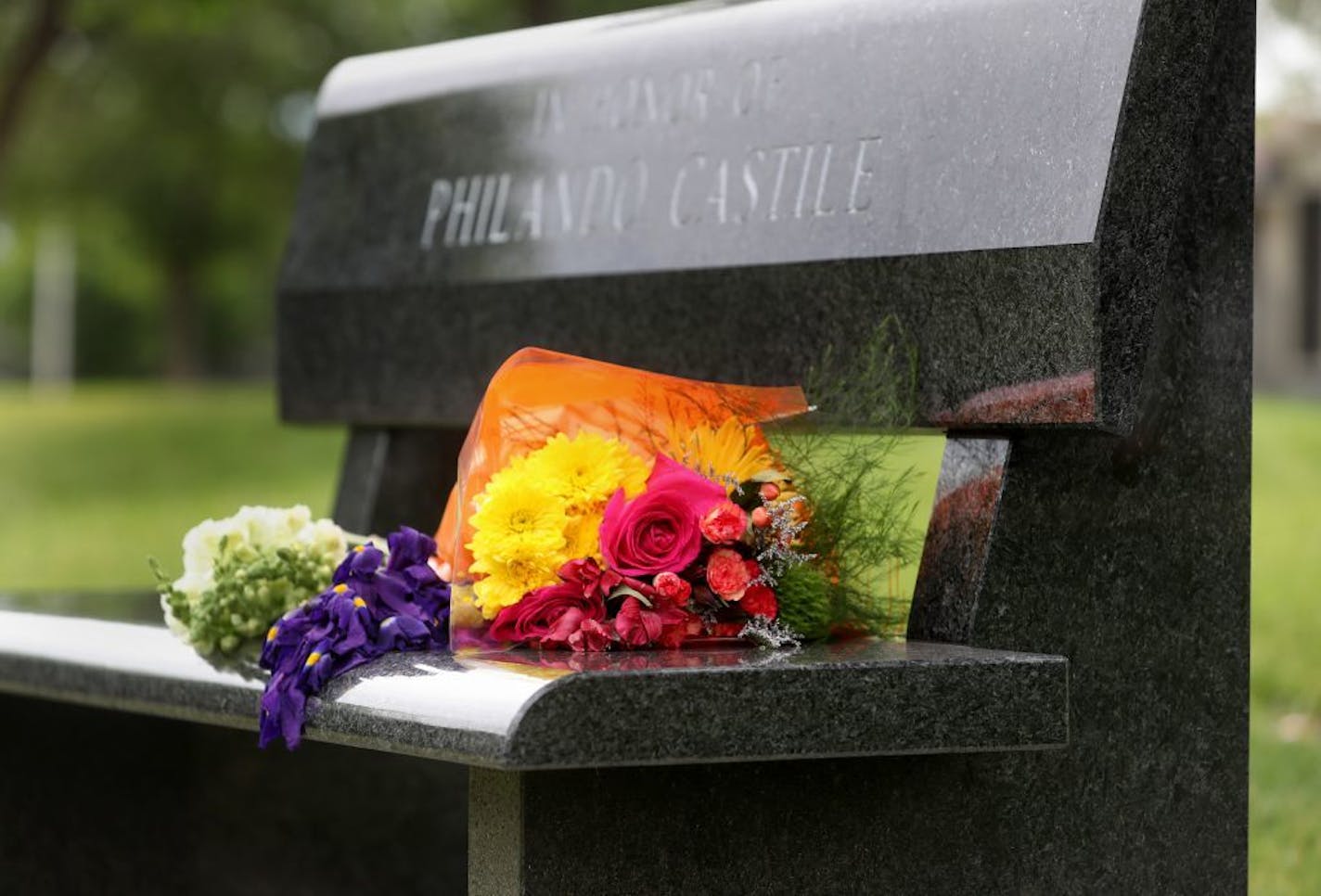 Flowers rest on a Memorial bench to Philando Castile, outside J.J. Hill Montessori Magnet School, where Castile worked as a nutrition services supervisor and was seen Saturday, June 17, 2017. Castile was fatally shot by St. Anthony officer Jeronimo Yanez during a traffic stop on July 6. Yanez was acquitted of all charges in a verdict at the Ramsey County Courthouse Friday.