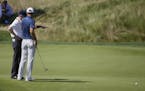 Dustin Johnson, right, talks to a rules official on the fifth green during the final round of the U.S. Open golf championship at Oakmont Country Club 