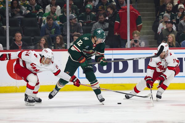 Wild left winger Matt Boldy (12) raced after the puck between Hurricanes center Seth Jarvis (24) and center Jordan Staal during the first period of Ca