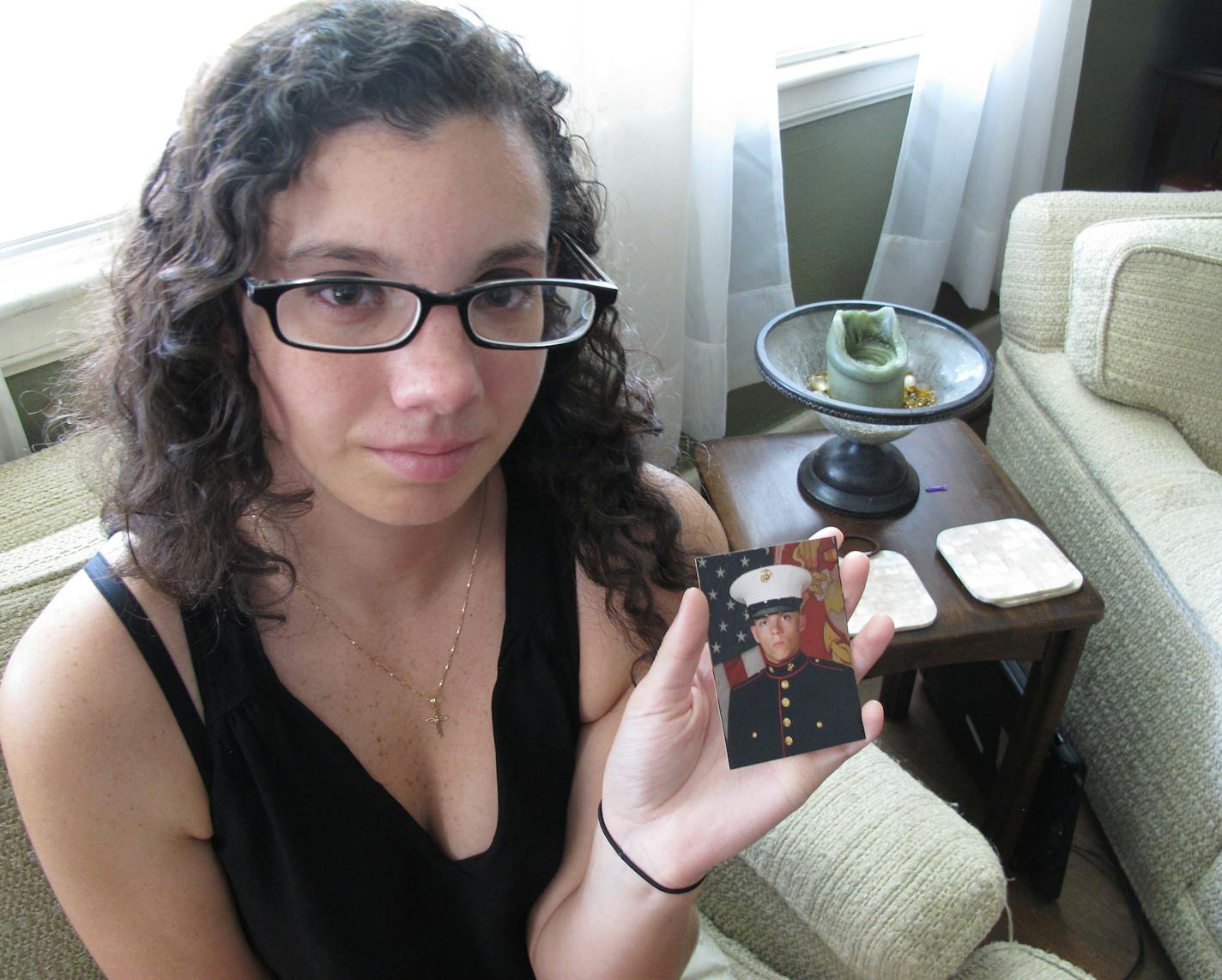 Caroline Dove holds a photo of Marine Corps Lance Cpl. Skip Wells, her boyfriend, in her hands July 17, 2015, at her home in Savannah, Ga. Wells was among four Marines killed July 16, 2015, in an attack at a military training facility in Chattanooga, Tenn. Muhammad Youssef Abdulazeez opened fire Thursday, July 16, 2015, on two U.S. military sites in Chattanooga in an attack that left four Marines dead and raised the specter of terrorism on U.S. soil. He was killed by police.(AP Photo/Russ Bynum)