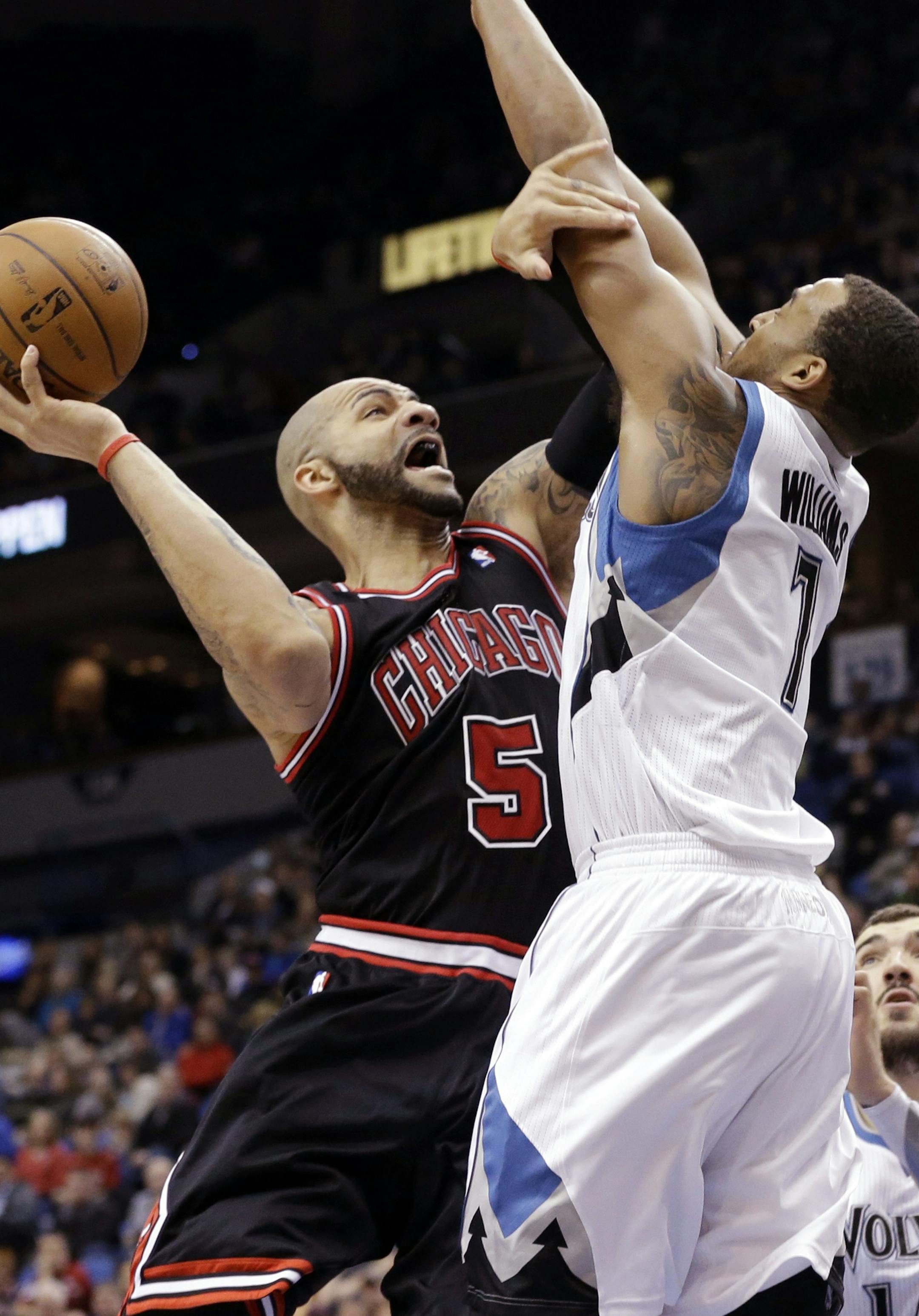 Chicago Bulls' Carlos Boozer, left, tries to clear away Minnesota Timberwolves defender Derrick Williams in the second half of an NBA basketball game Sunday, March 24, 2013, in Minneapolis. The Bulls won 104-97. Boozer scored 19 points and had 12 rebounds. (AP Photo/Jim Mone)